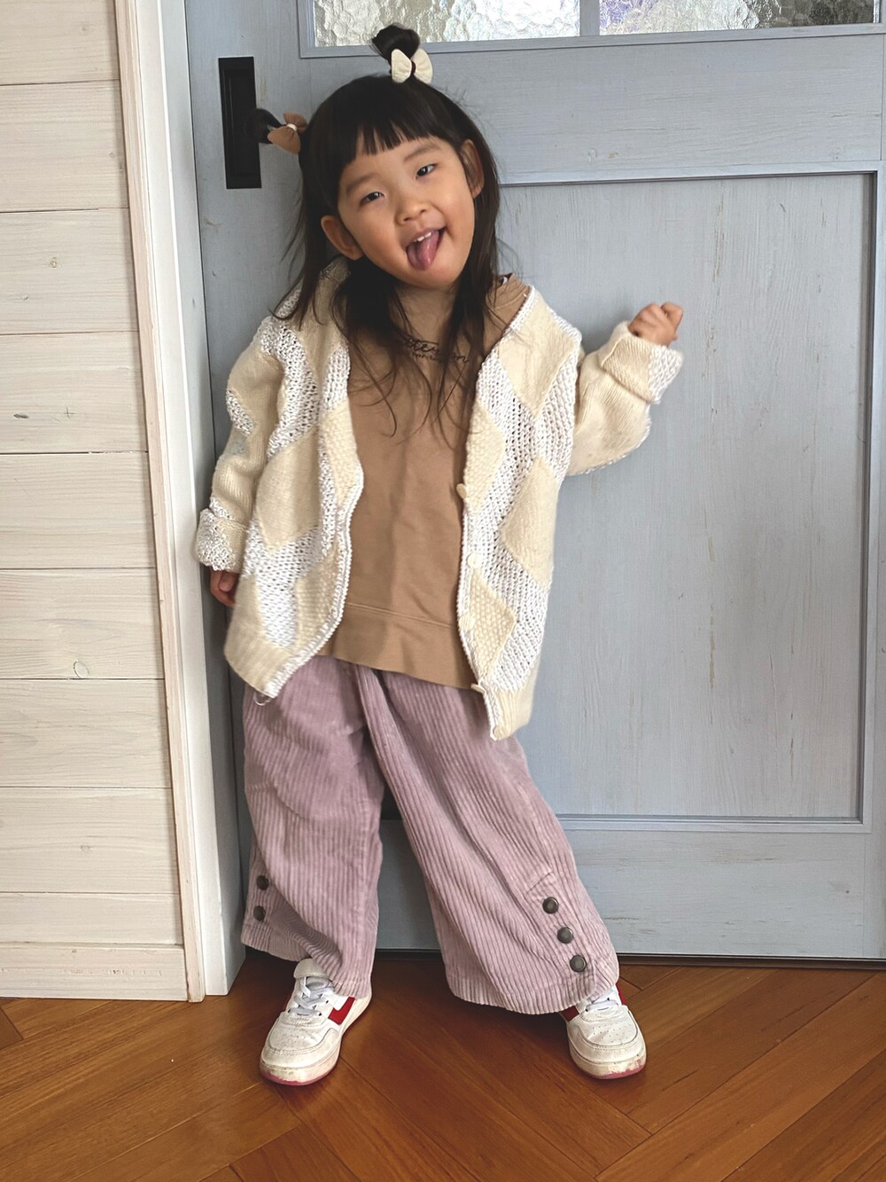 ベージュ系のスウェット、ピンク系のパンツ、ホワイト系のカーディガン/ボレロを着用したキッズの冬コーディネートの2枚目の写真