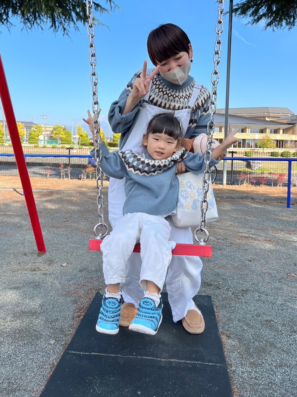 ブルー系のニット/セーター、ブルー系のスニーカー、ホワイト系のサロペット/オーバーオールを着用したキッズの秋コーディネートの2枚目の写真