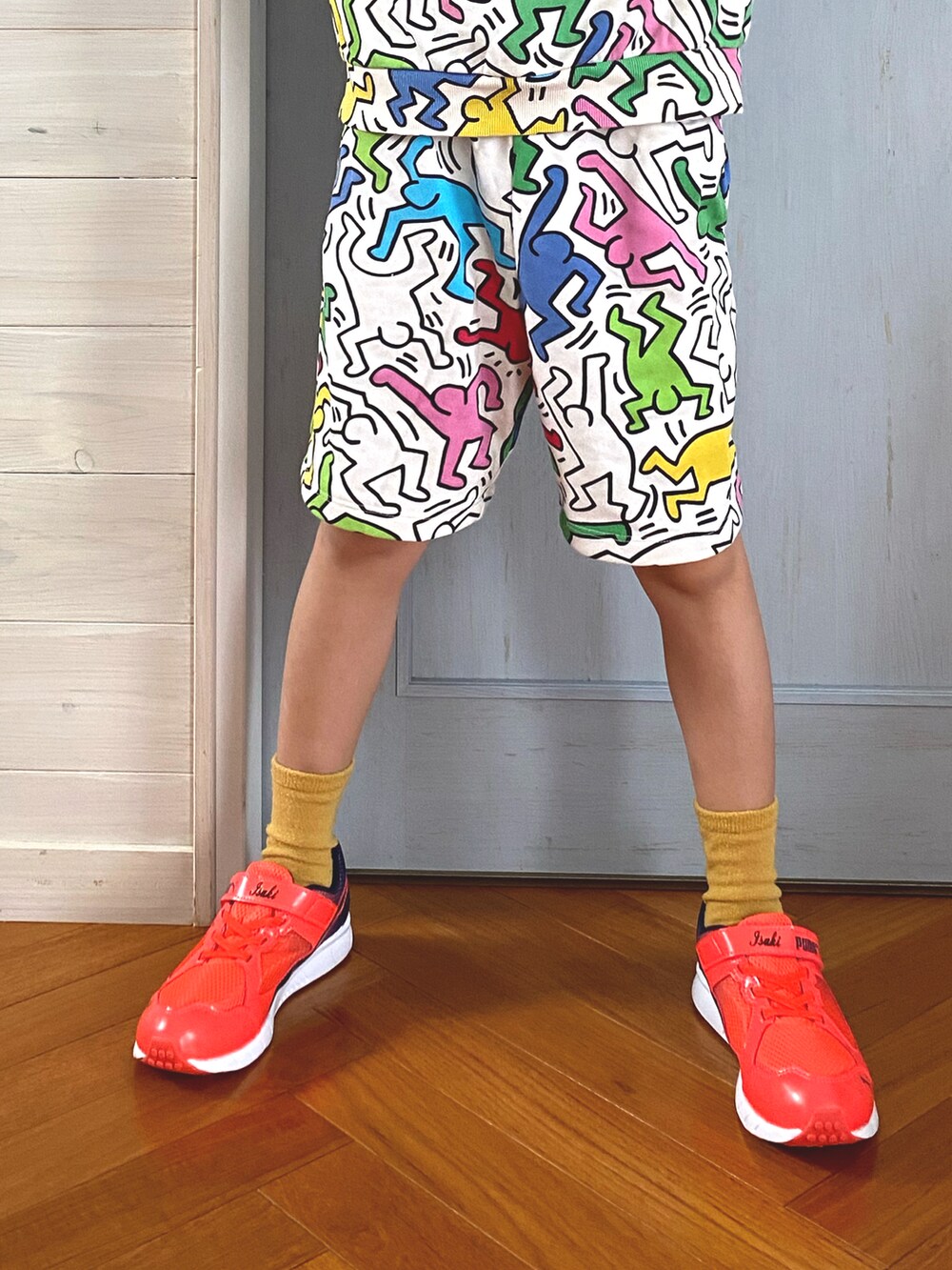 オレンジ系のスニーカー、ホワイト系のセットアップ、ブルー系のキャップを着用したキッズの春コーディネートの2枚目の写真