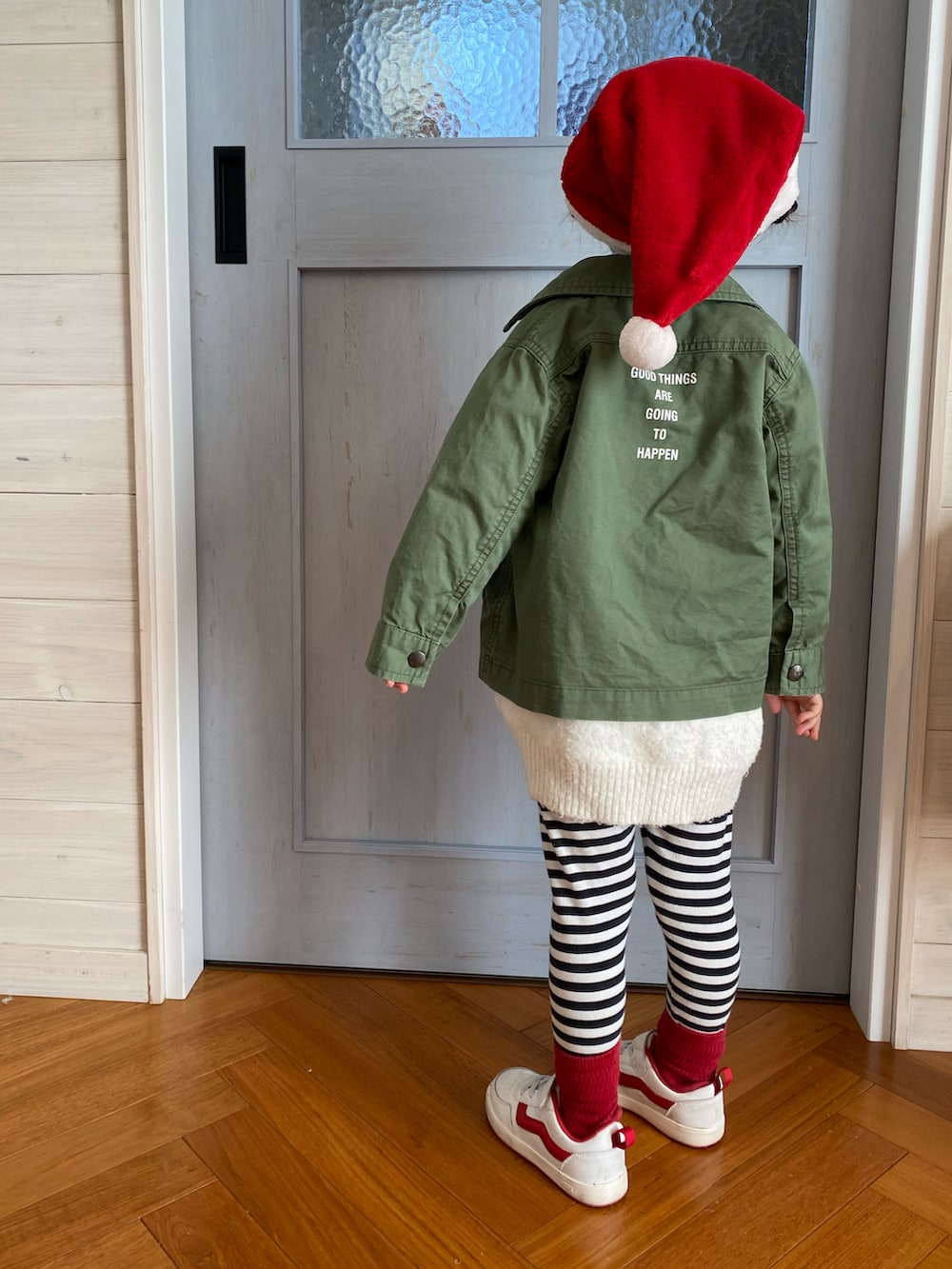 ホワイト系のニット/セーター、グリーン系のカバーオール、ホワイト系のスニーカーを着用したキッズの冬コーディネートの2枚目の写真