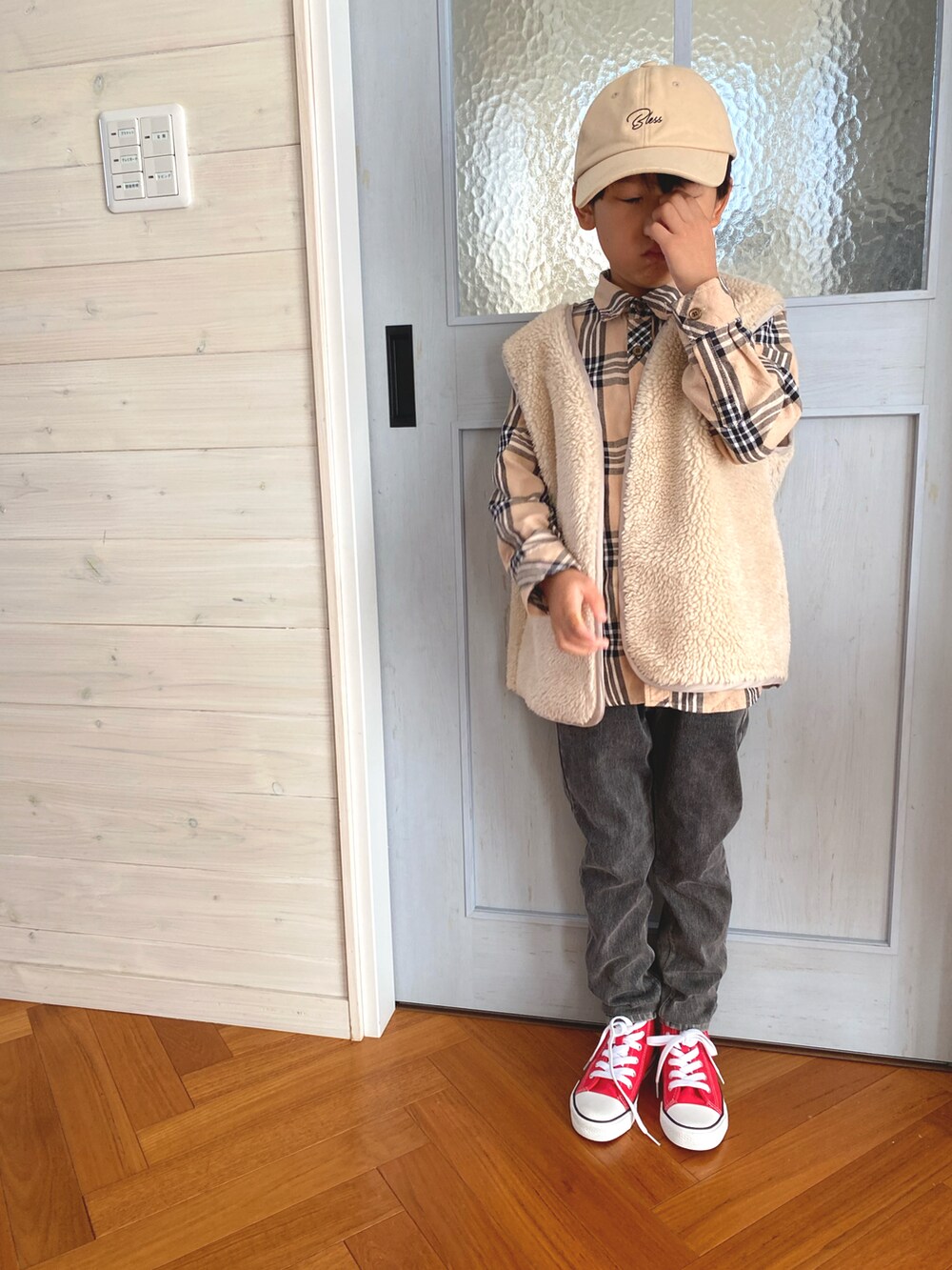 ホワイト系のスウェット、ブラック系のデニムパンツ、レッド系のスニーカーを着用したキッズの秋コーディネートの2枚目の写真