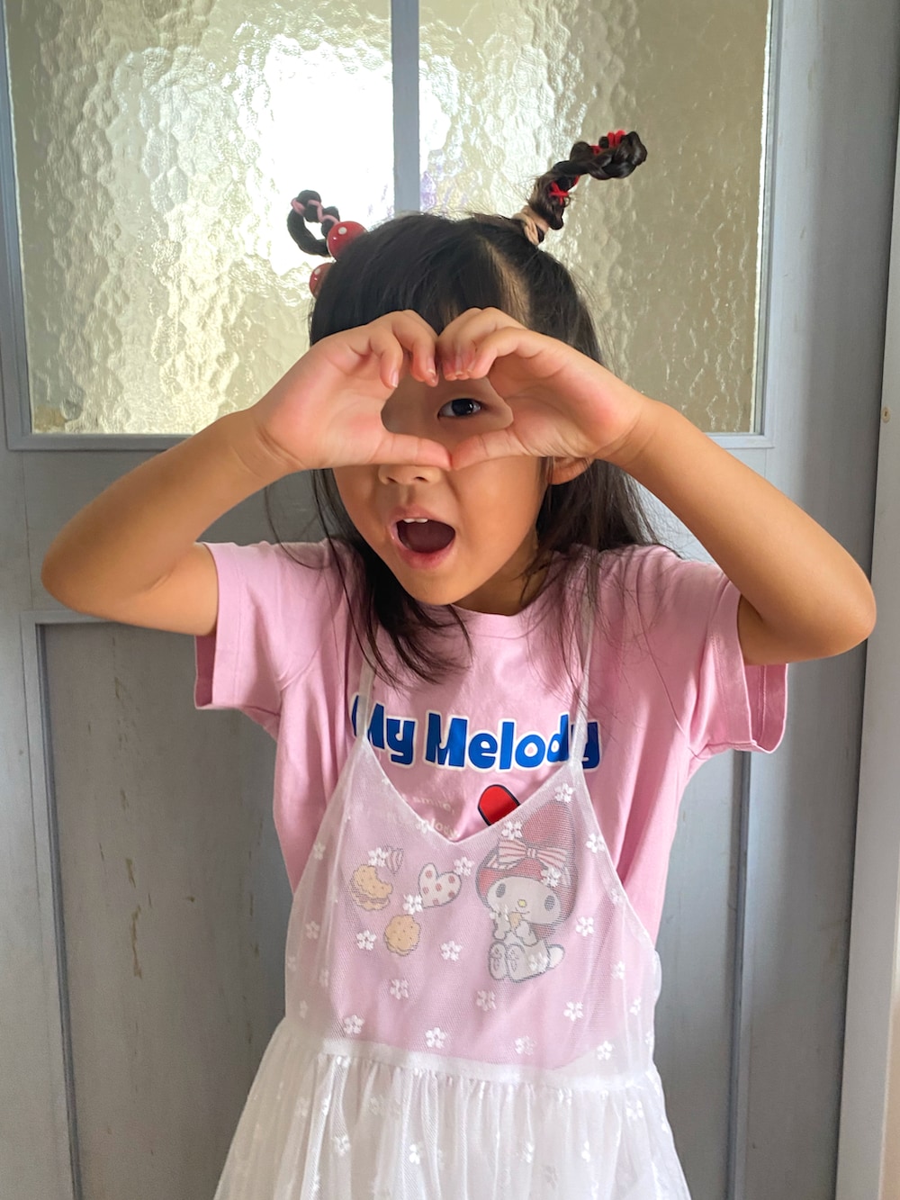 ホワイト系のワンピース、ホワイト系のスニーカー、ピンク系のTシャツ/カットソーを着用したキッズの夏コーディネートの2枚目の写真