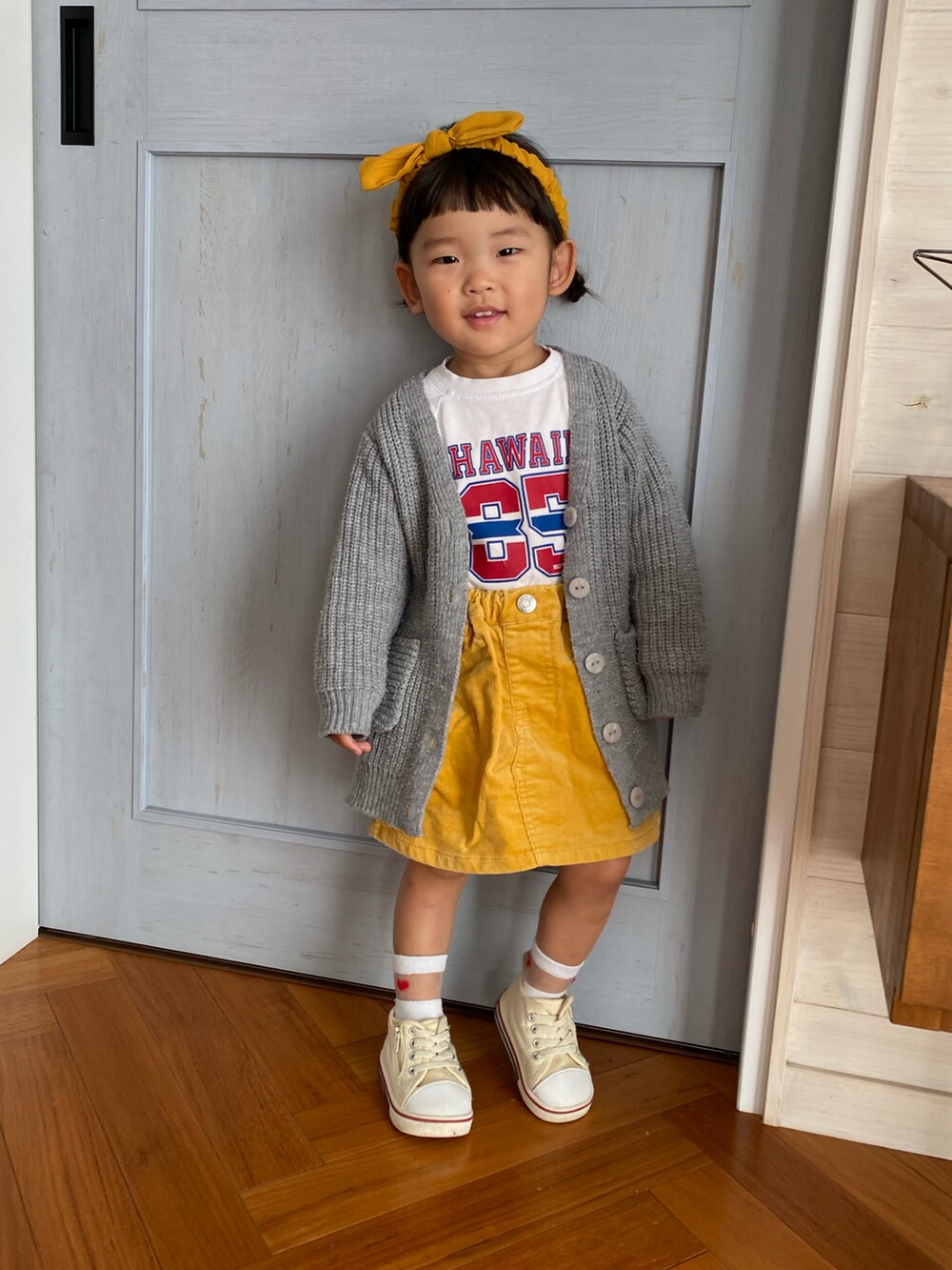 ホワイト系のTシャツ/カットソー、イエロー系のスカート、ホワイト系のスニーカーを着用したキッズの秋コーディネートの2枚目の写真