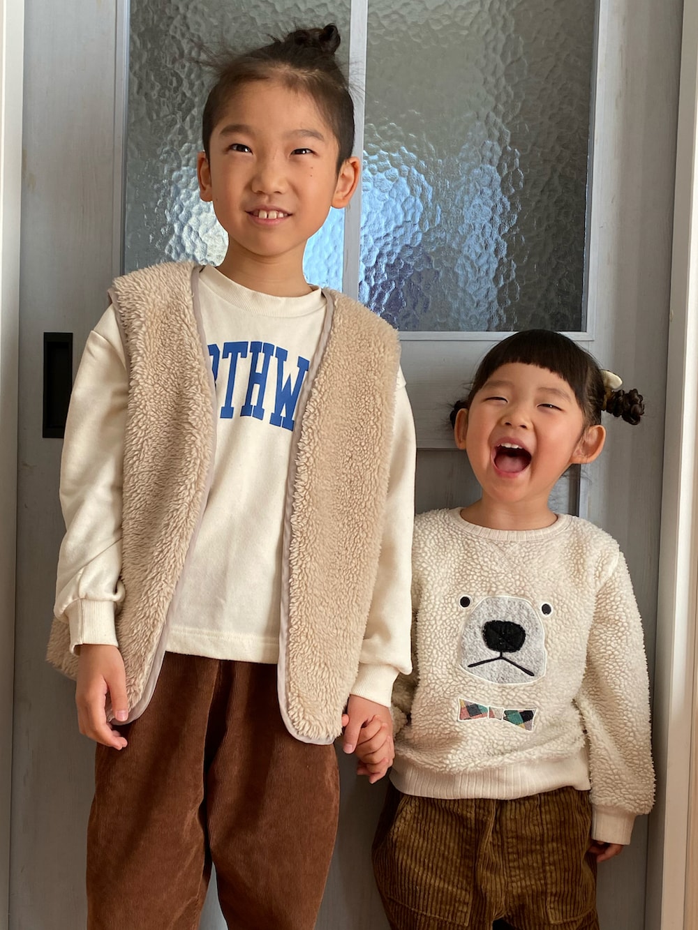 ホワイト系のスウェット、ブラウン系のパンツ、ホワイト系のニット/セーターを着用したキッズの冬コーディネートの2枚目の写真