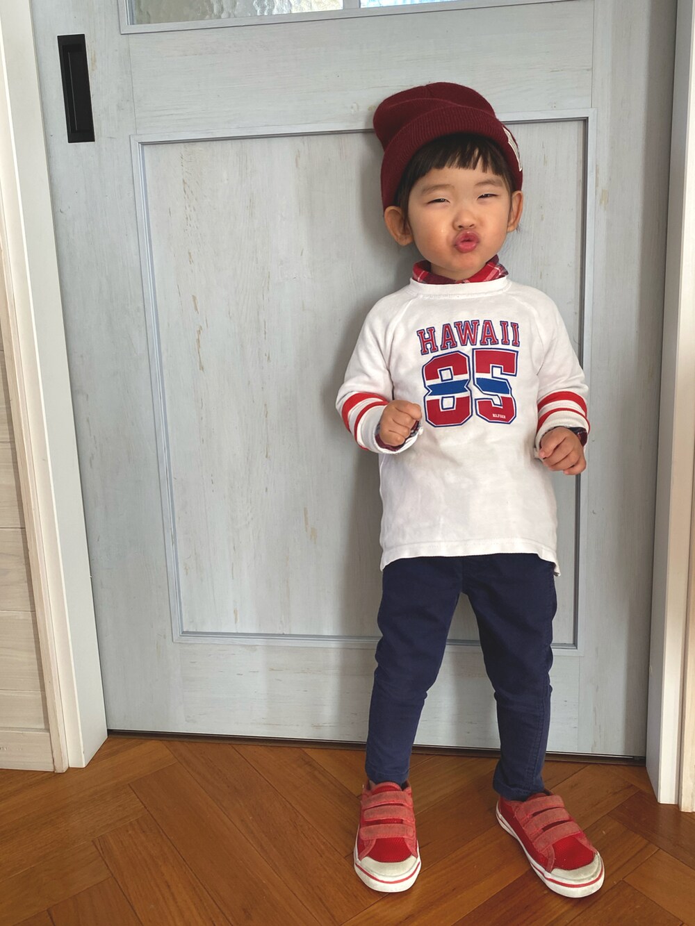 ホワイト系のTシャツ/カットソー、ブルー系のパンツ、レッド系のスニーカーを着用したキッズの冬コーディネートの2枚目の写真