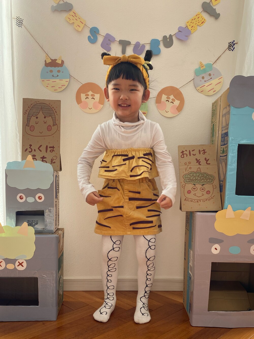 イエロー系のスカート、ホワイト系のタイツ/ストッキング、イエロー系のスタイ/よだれかけを着用したキッズの冬コーディネートの2枚目の写真