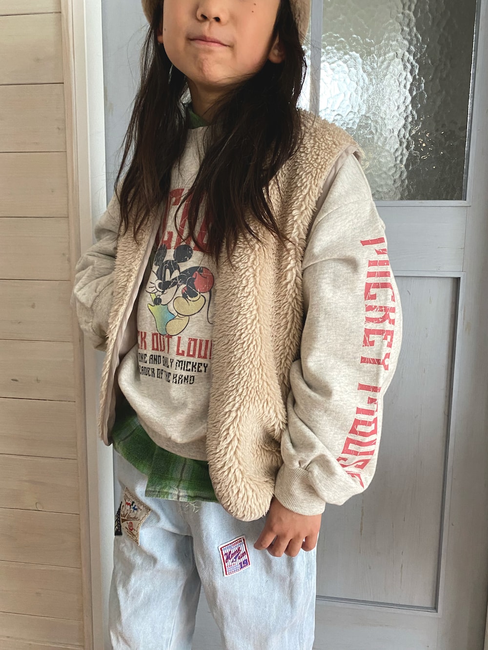 ブルー系のデニムパンツ、イエロー系のモカシン/デッキシューズ、ホワイト系のスウェットを着用したキッズの冬コーディネートの2枚目の写真