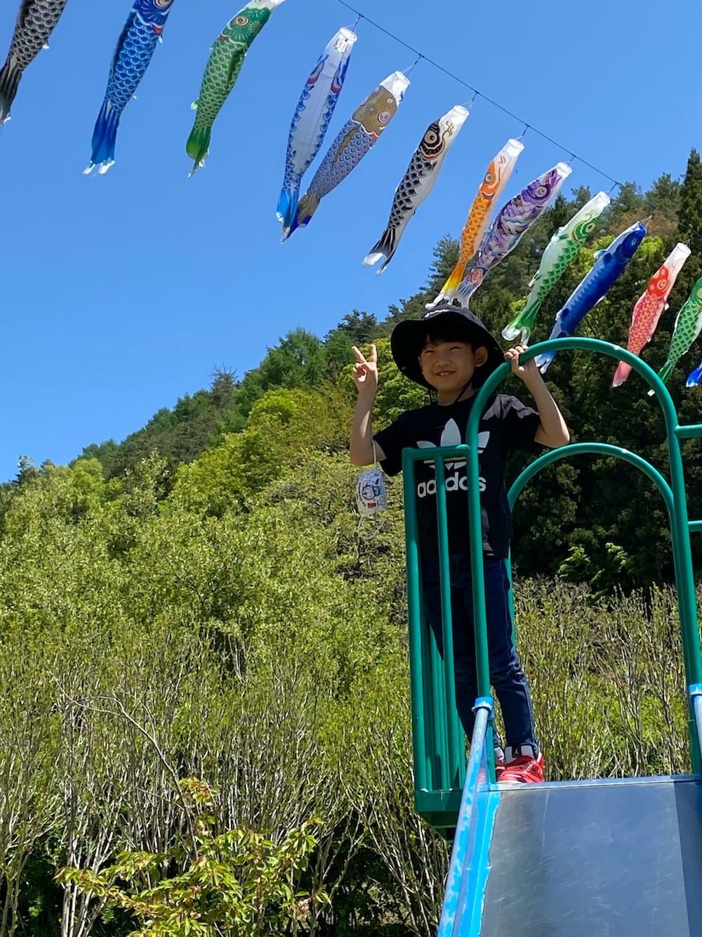 ブラック系のTシャツ/カットソー、レッド系のスニーカー、ホワイト系のスニーカーを着用したキッズの春コーディネートの3枚目の写真