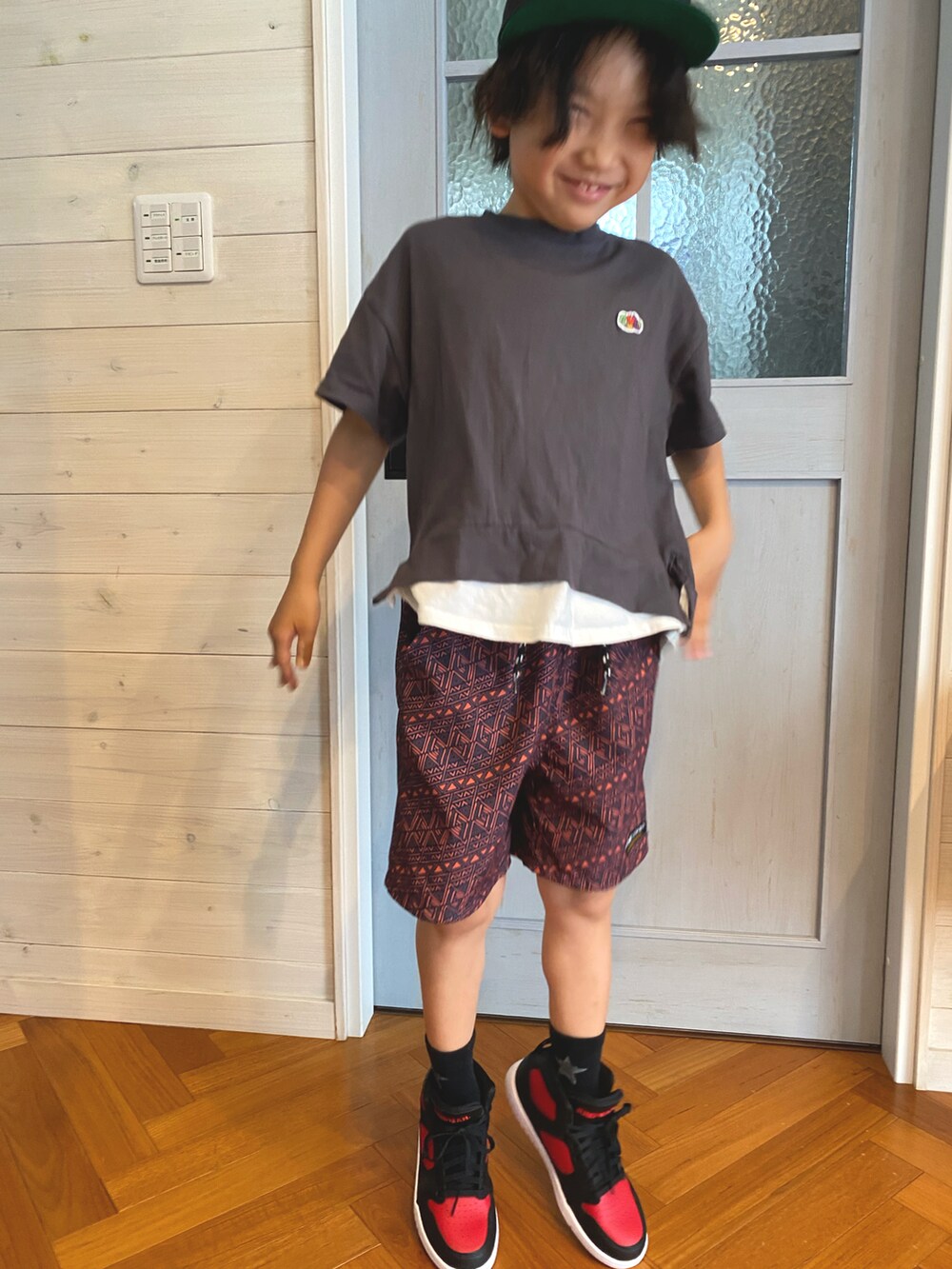 ブラック系のTシャツ/カットソー、レッド系のその他パンツ、レッド系のスニーカーを着用したキッズの春コーディネートの2枚目の写真