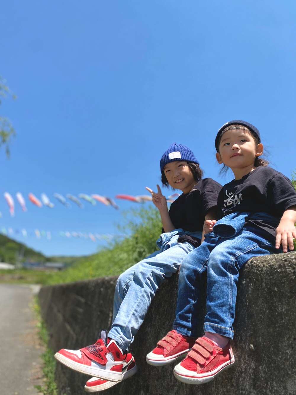 ブラック系のTシャツ/カットソー、レッド系のスニーカー、レッド系のスニーカーを着用したキッズの春コーディネートの2枚目の写真