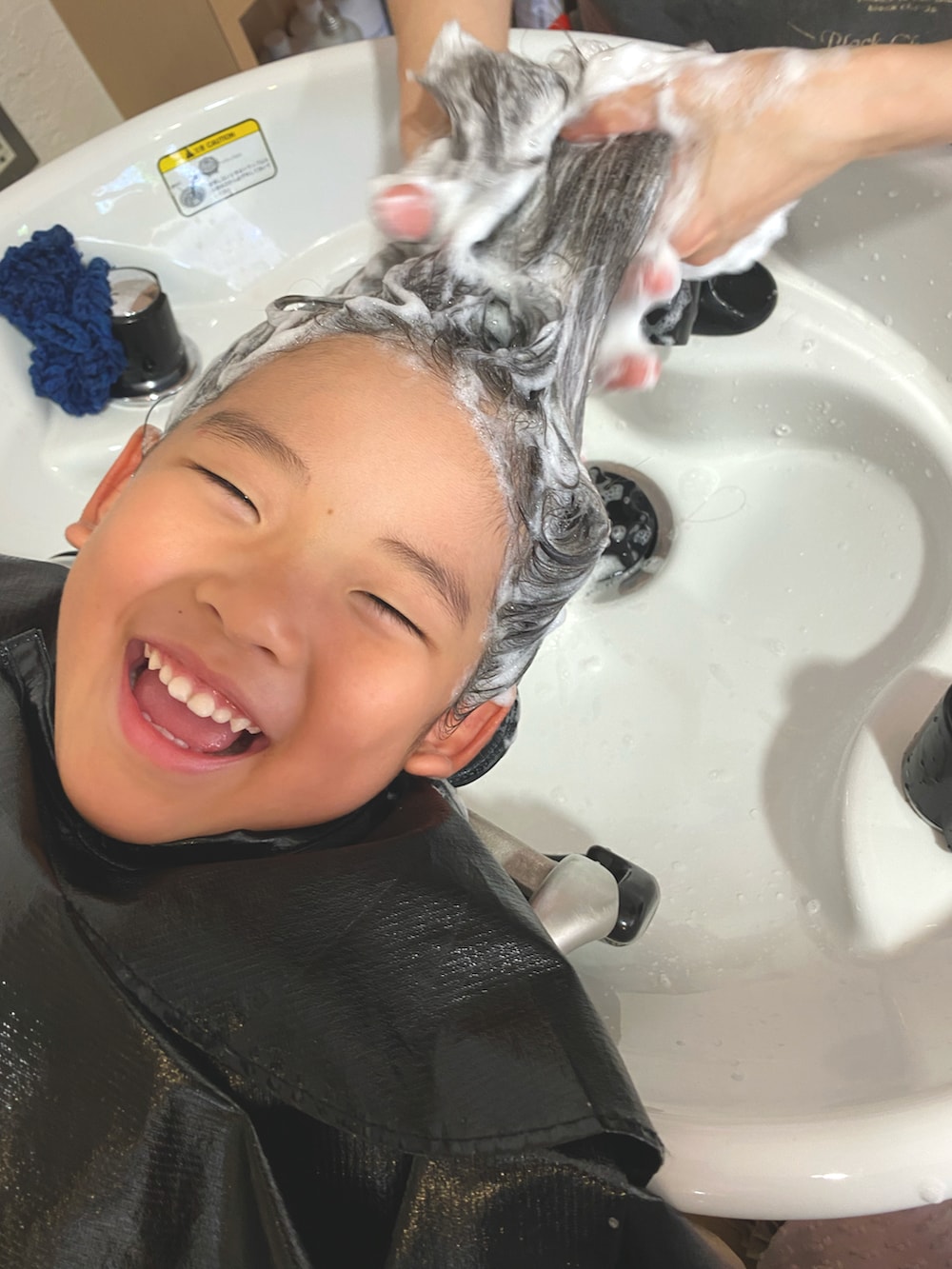 ホワイト系のワンピース、ベージュ系のサンダルを着用したキッズの夏コーディネートの3枚目の写真