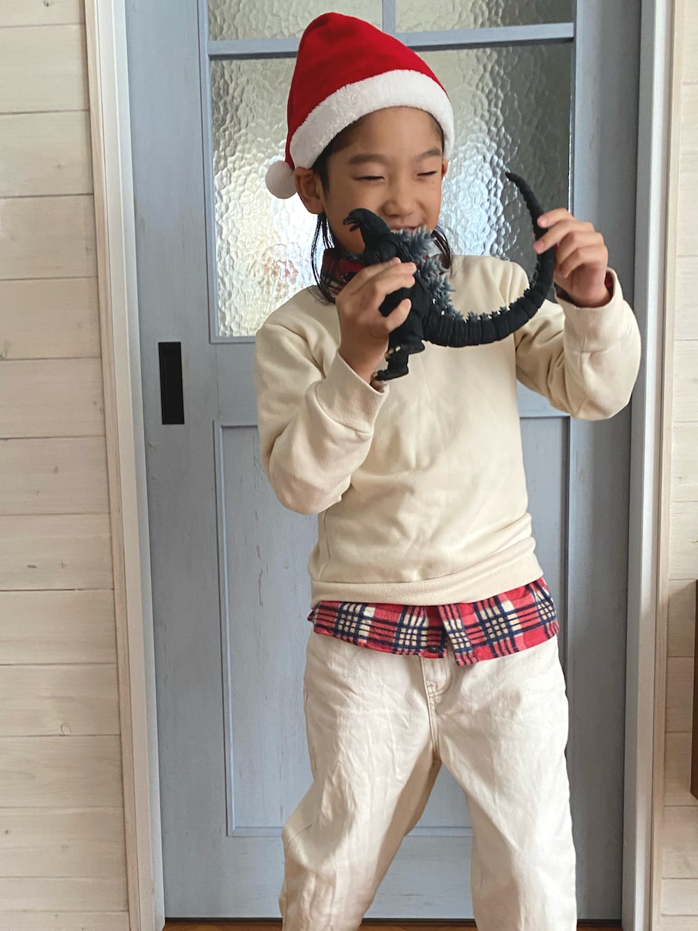 ホワイト系のデニムパンツ、レッド系のシャツ/ブラウス、レッド系の帽子を着用したキッズの冬コーディネートの2枚目の写真