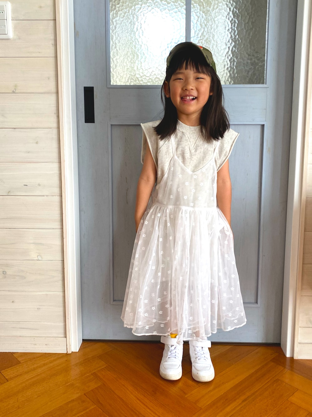 ホワイト系のセットアップ、ホワイト系のワンピース、ホワイト系のスニーカーを着用したキッズの春コーディネートの3枚目の写真