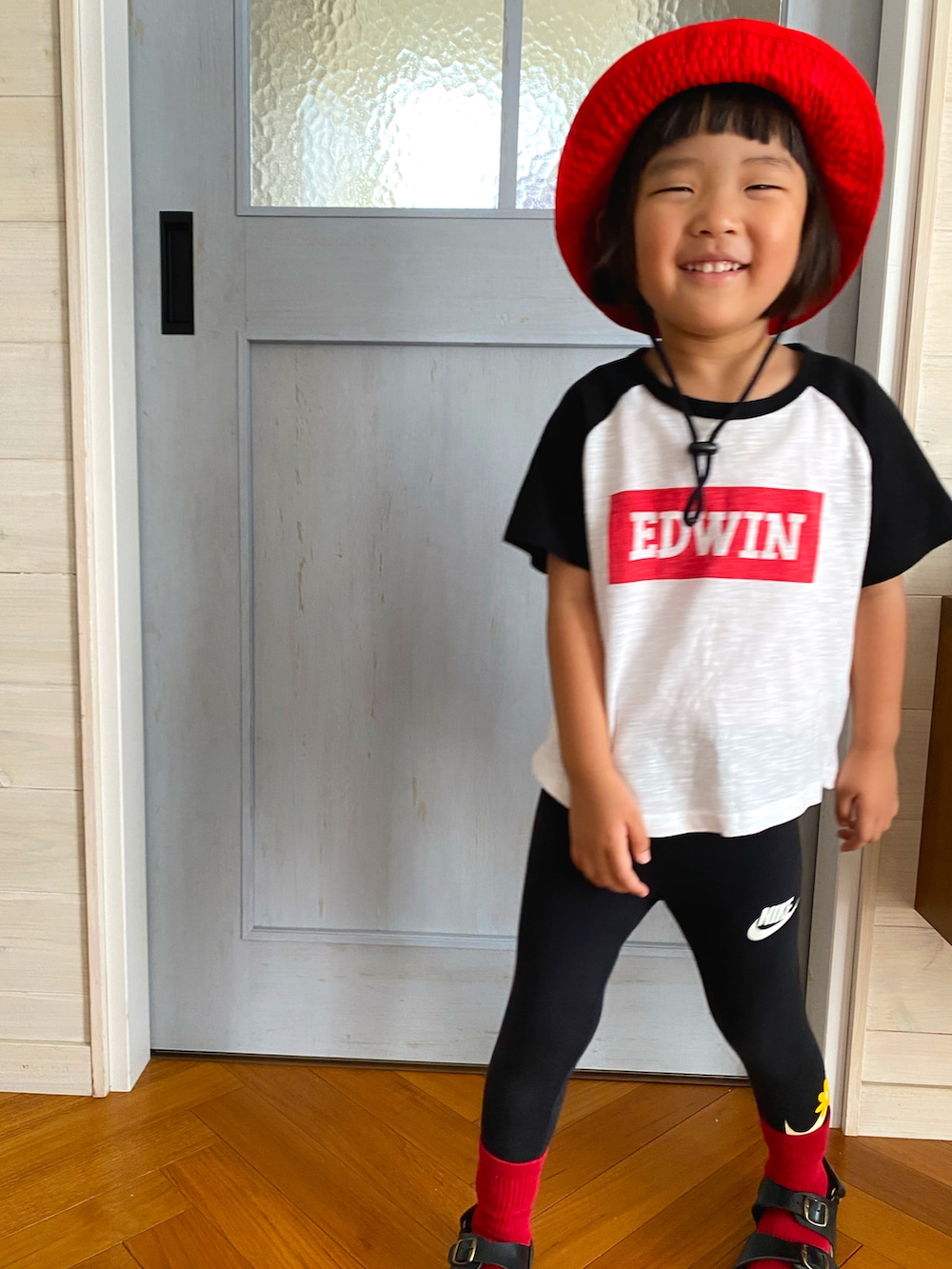 ブラック系のサンダル、ホワイト系のTシャツ/カットソー、レッド系のハットを着用したキッズの夏コーディネートの2枚目の写真