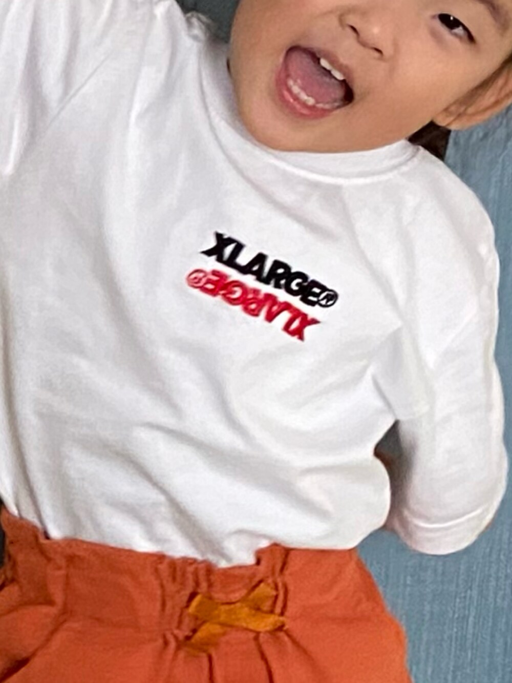 オレンジ系のパンツ、ホワイト系のTシャツ/カットソー、ホワイト系のソックス/靴下を着用したキッズの秋コーディネートの3枚目の写真