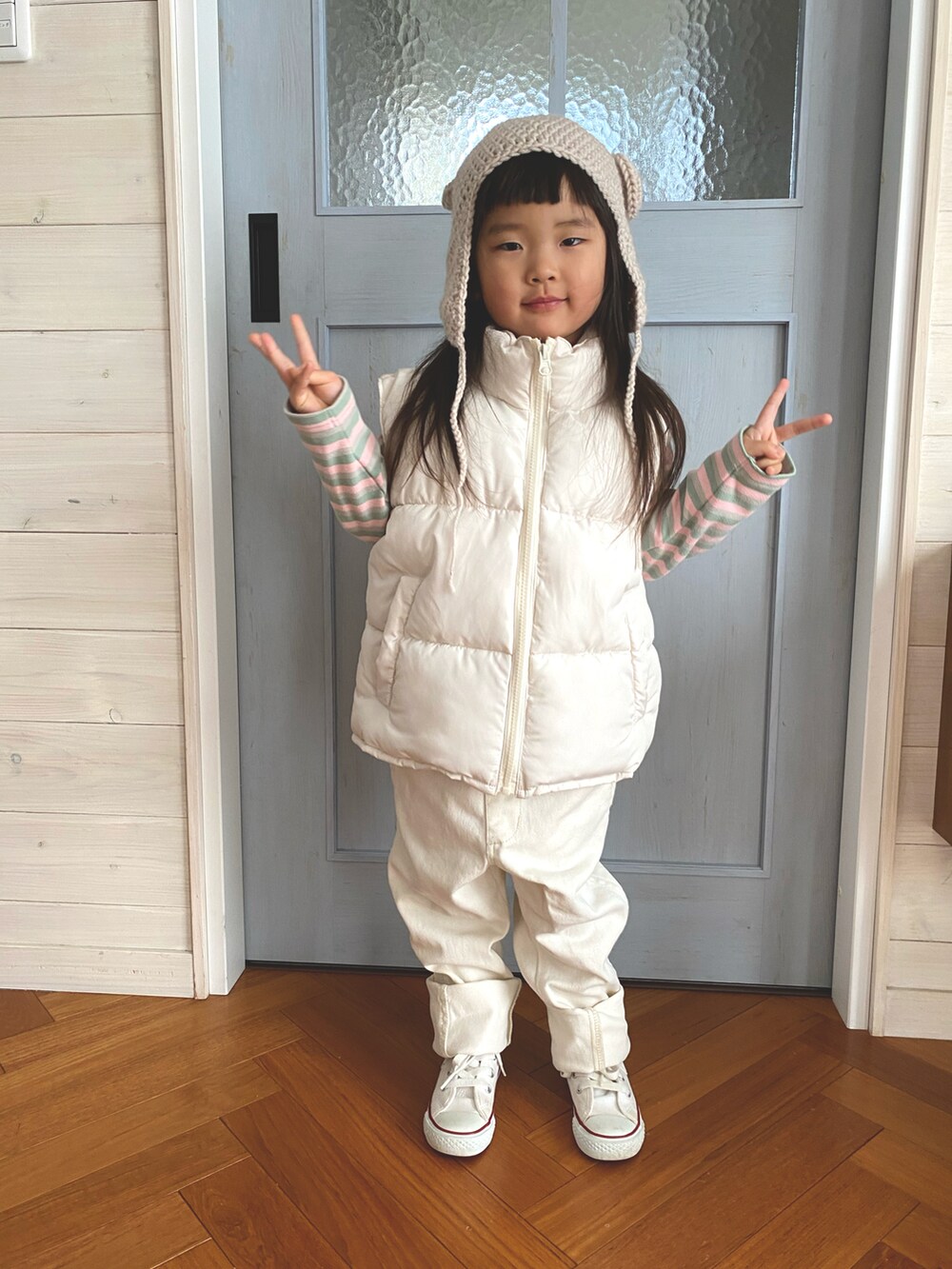ホワイト系のダウンベスト、ホワイト系のサロペット/オーバーオール、ピンク系のTシャツ/カットソーを着用したキッズの冬コーディネートの2枚目の写真