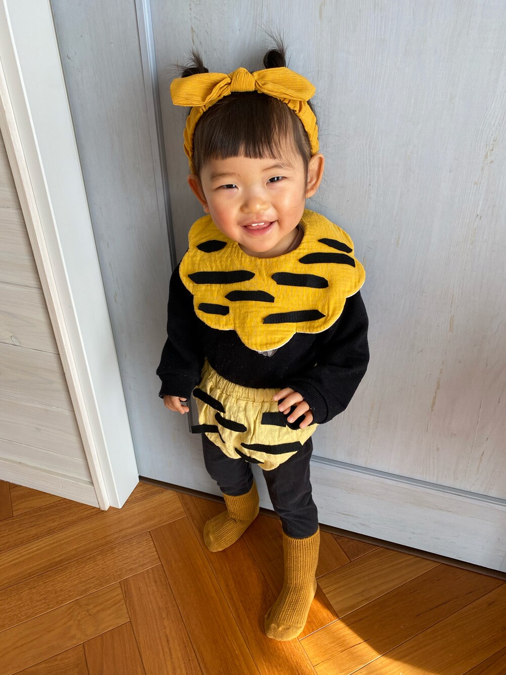 イエロー系のその他パンツ、イエロー系のヘアバンド、イエロー系のスタイ/よだれかけを着用したキッズの冬コーディネートの2枚目の写真