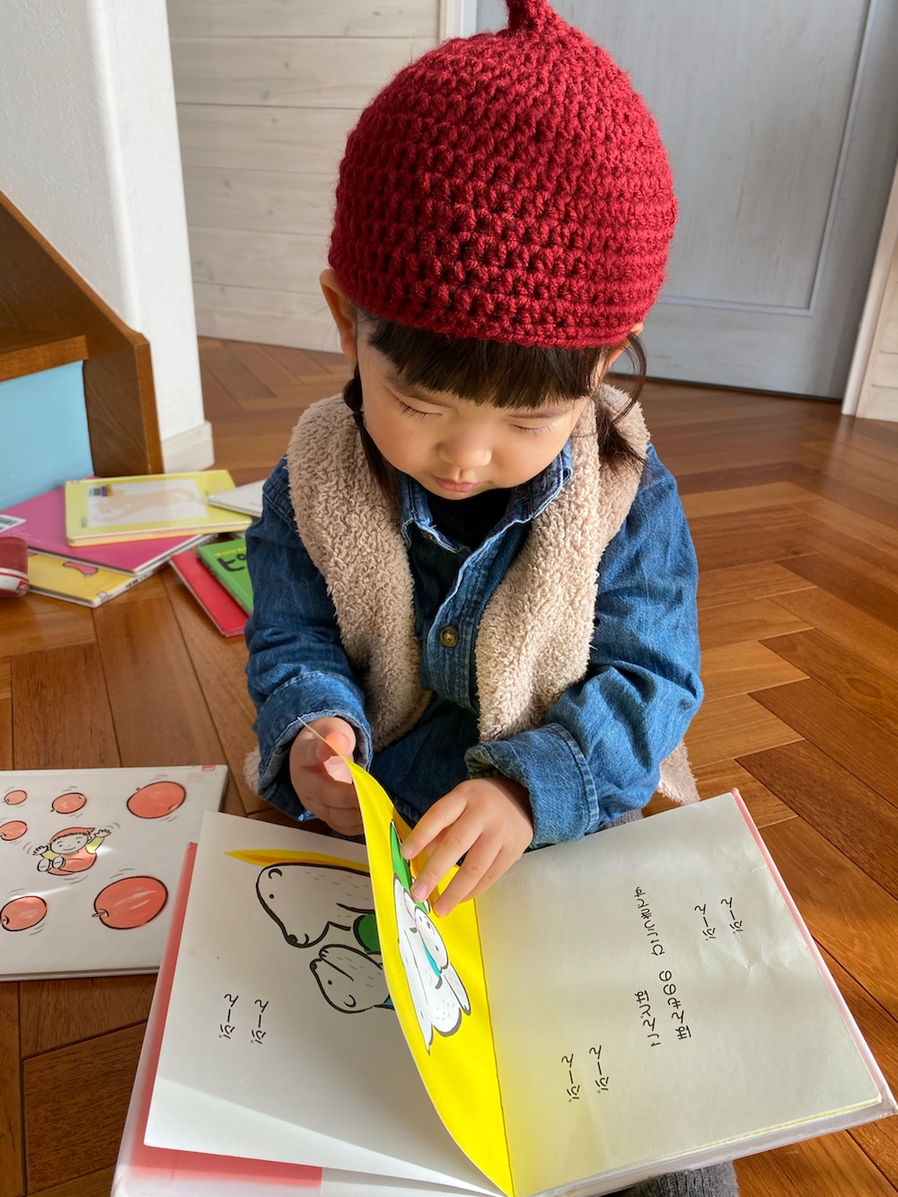 ブルー系のシャツ/ブラウス、レッド系のスニーカー、レッド系のニットキャップ/ビーニーを着用したキッズの冬コーディネートの3枚目の写真