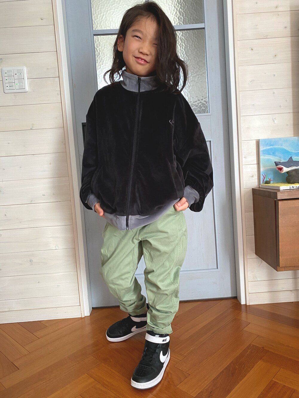 ブラック系のブルゾン、グリーン系のパンツ、ブラック系のスニーカーを着用したキッズの冬コーディネートの2枚目の写真