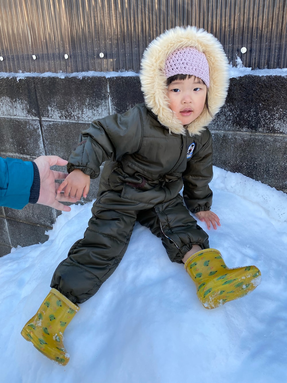 グリーン系のジャケット/アウター、ピンク系のニットキャップ/ビーニーを着用したキッズの冬コーディネートの3枚目の写真
