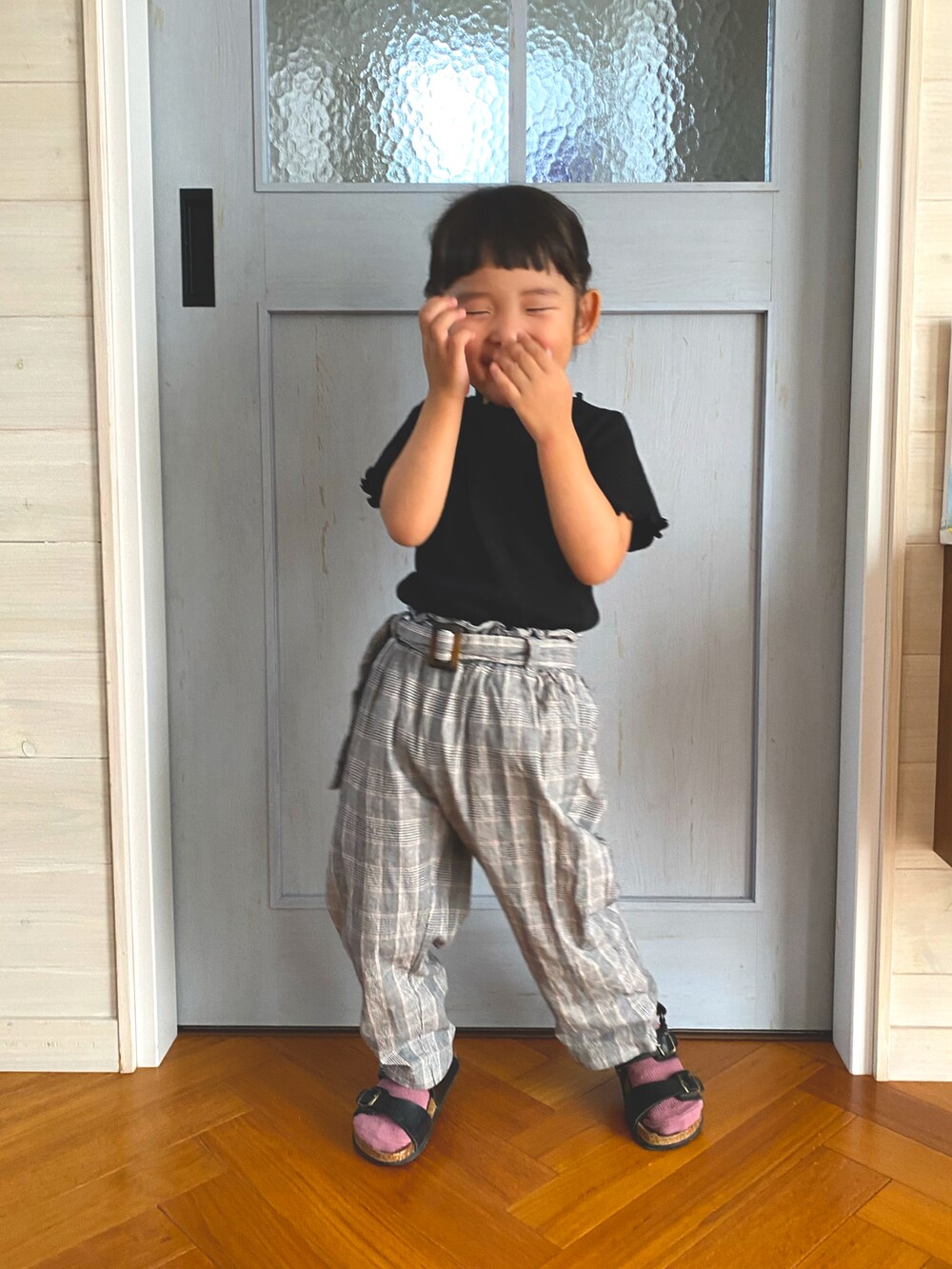 ブラック系のTシャツ/カットソー、グレー系のパンツ、ブラック系のサンダルを着用したキッズの秋コーディネートの3枚目の写真