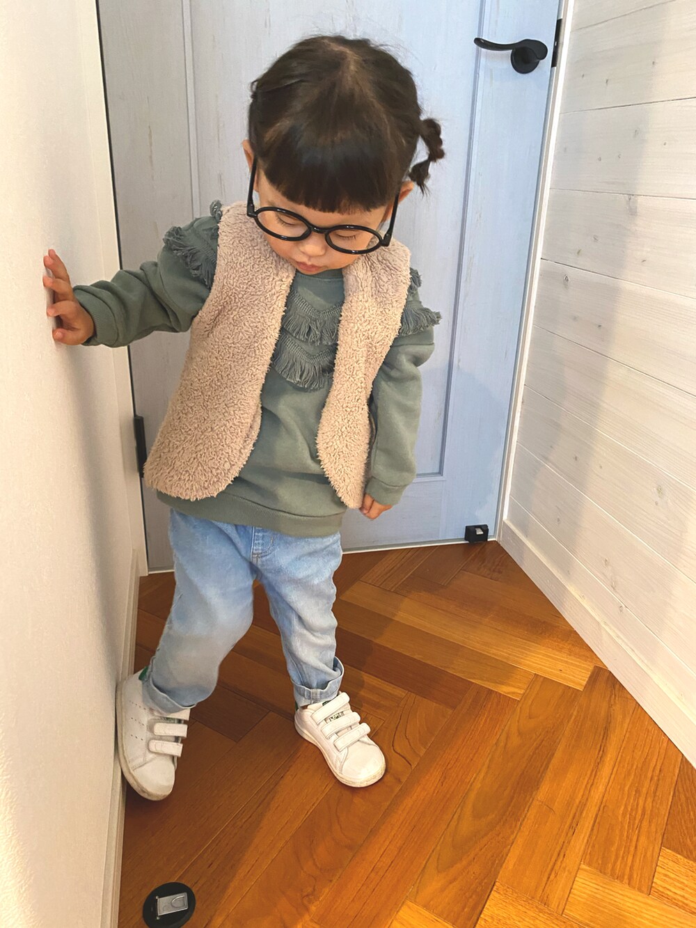 グリーン系のスウェット、ベージュ系のダウンベスト、ブラック系のメガネを着用したキッズの秋コーディネートの3枚目の写真