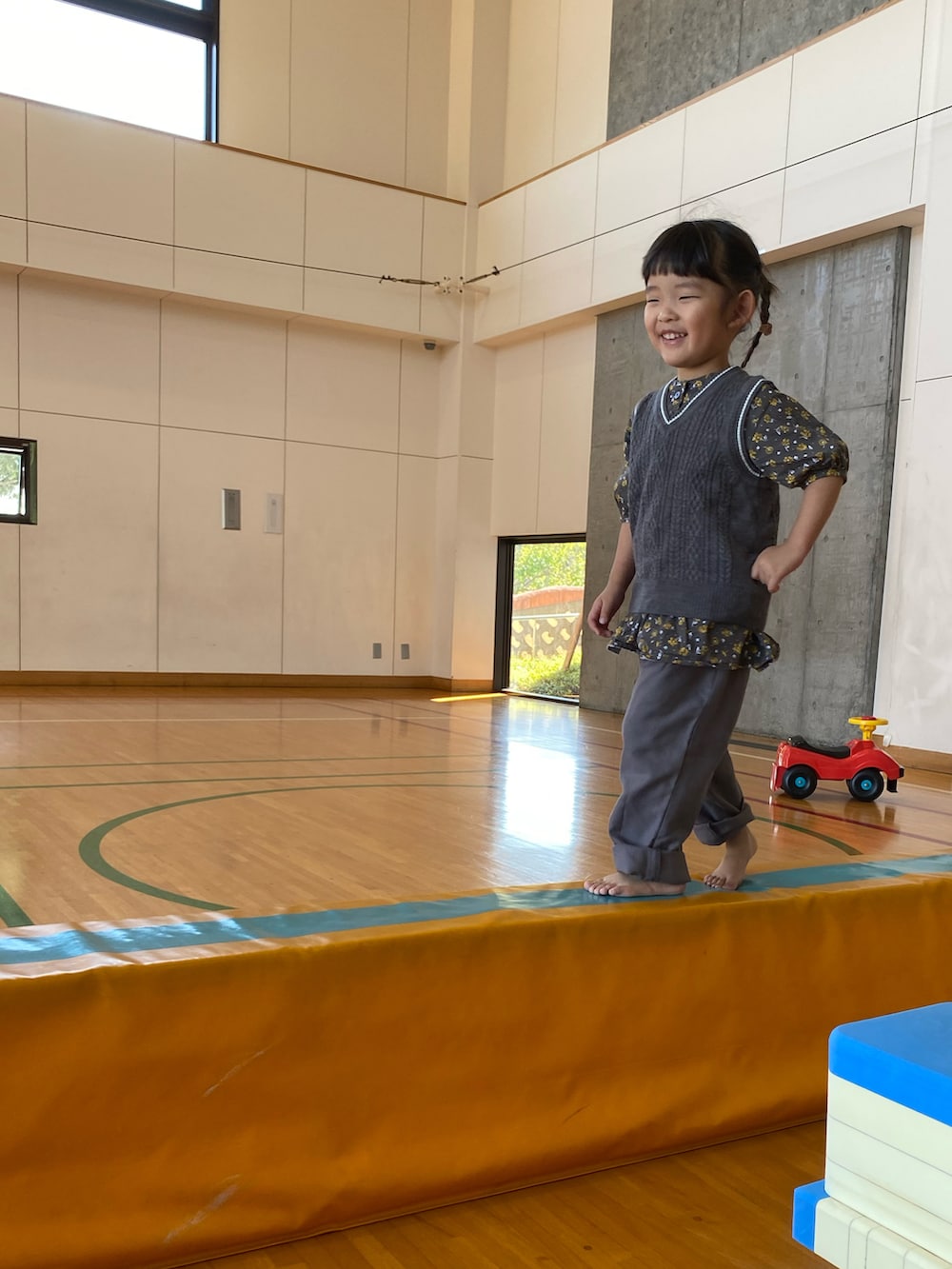 グレー系のベスト、ブラック系のワンピース、グレー系のその他パンツを着用したキッズの秋コーディネートの2枚目の写真