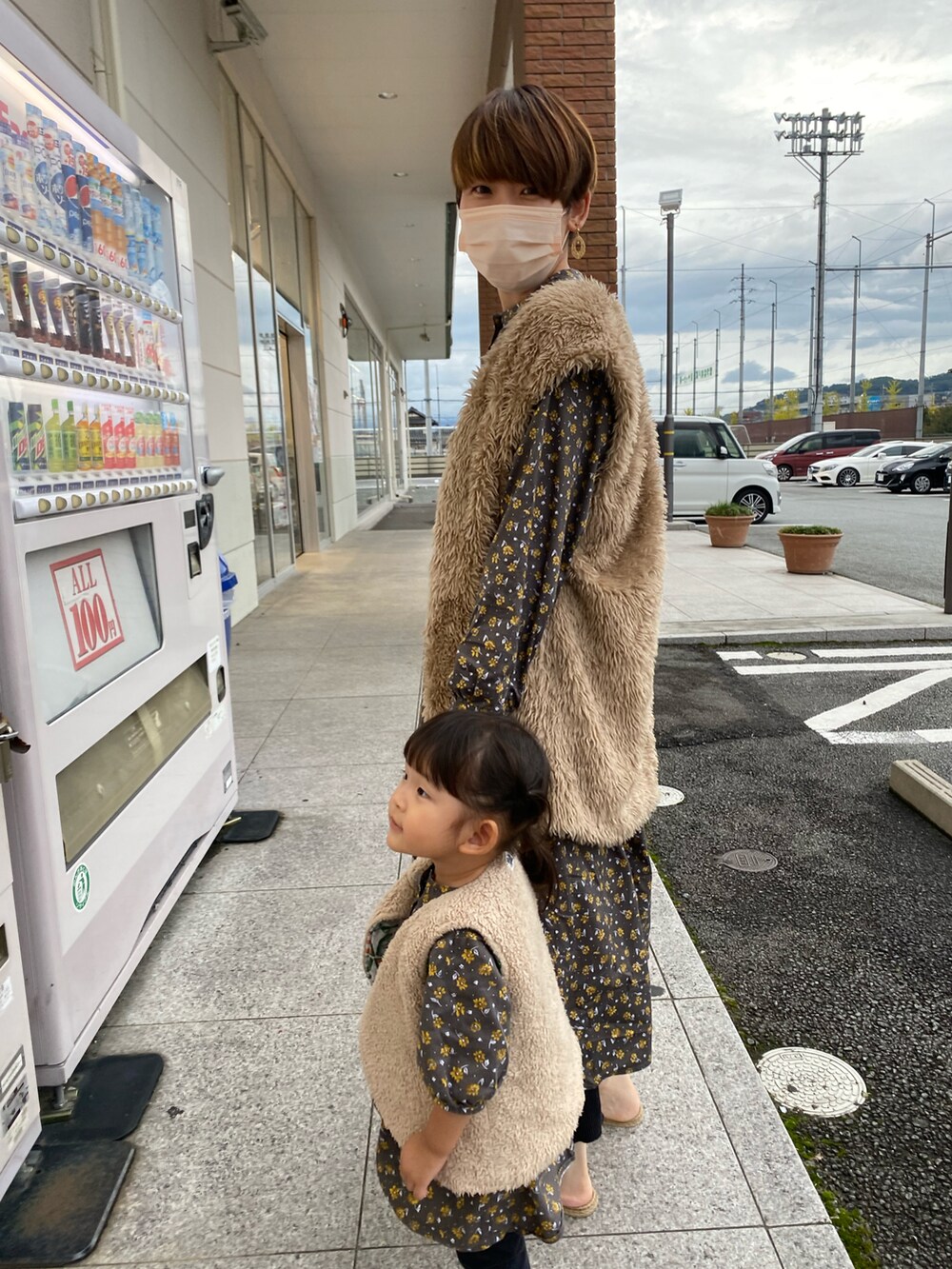 ベージュ系のダウンベスト、ベージュ系のベスト、グレー系のワンピースを着用したキッズの秋コーディネートの3枚目の写真