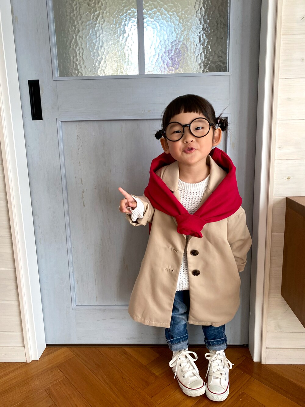 ベージュ系のチェスターコート、レッド系のスウェット、ホワイト系のスニーカーを着用したキッズの春コーディネートの3枚目の写真
