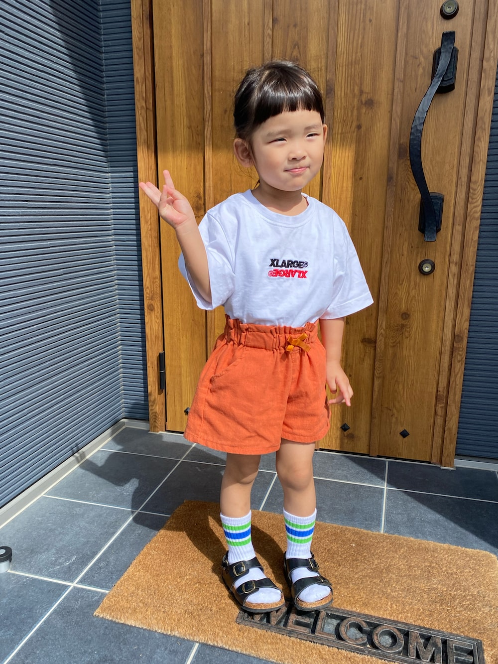オレンジ系のパンツ、ホワイト系のTシャツ/カットソー、ホワイト系のソックス/靴下を着用したキッズの秋コーディネートの2枚目の写真