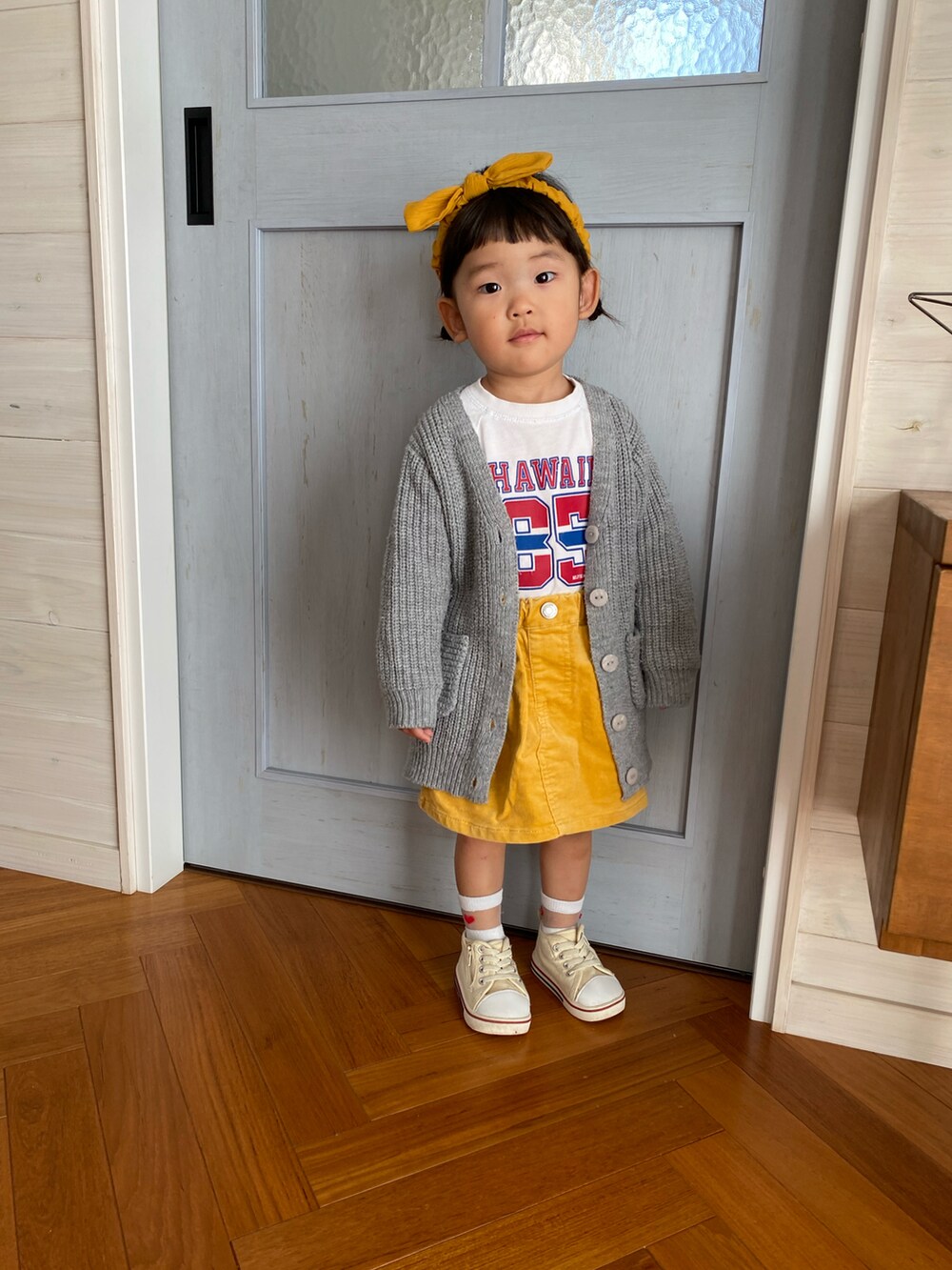 ホワイト系のTシャツ/カットソー、イエロー系のスカート、ホワイト系のスニーカーを着用したキッズの秋コーディネートの3枚目の写真