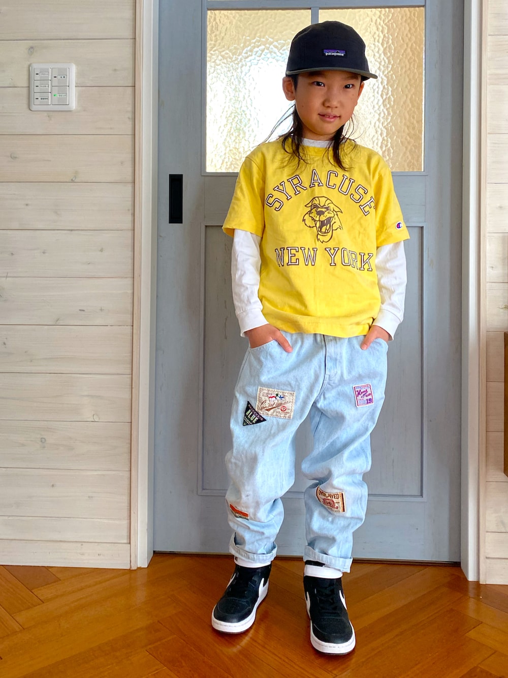 イエロー系のTシャツ/カットソー、ブルー系のデニムパンツ、ブラック系のスニーカーを着用したキッズの春コーディネートの2枚目の写真