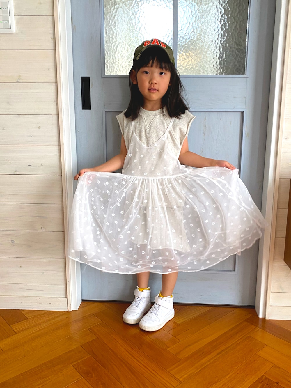 ホワイト系のセットアップ、ホワイト系のワンピース、ホワイト系のスニーカーを着用したキッズの春コーディネートの2枚目の写真