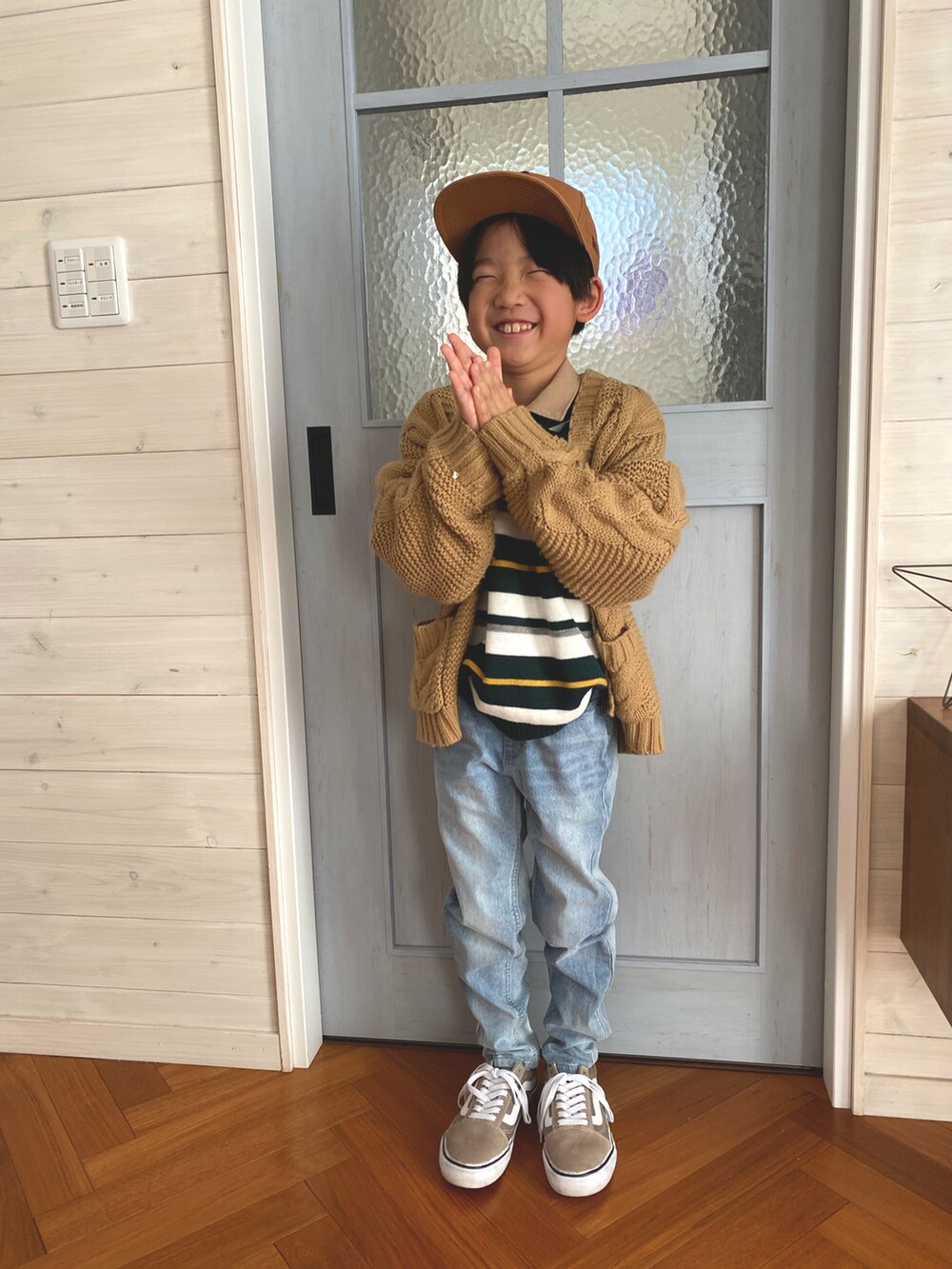 グリーン系のニット/セーター、ブルー系のデニムパンツ、ベージュ系のカーディガン/ボレロを着用したキッズの冬コーディネートの2枚目の写真