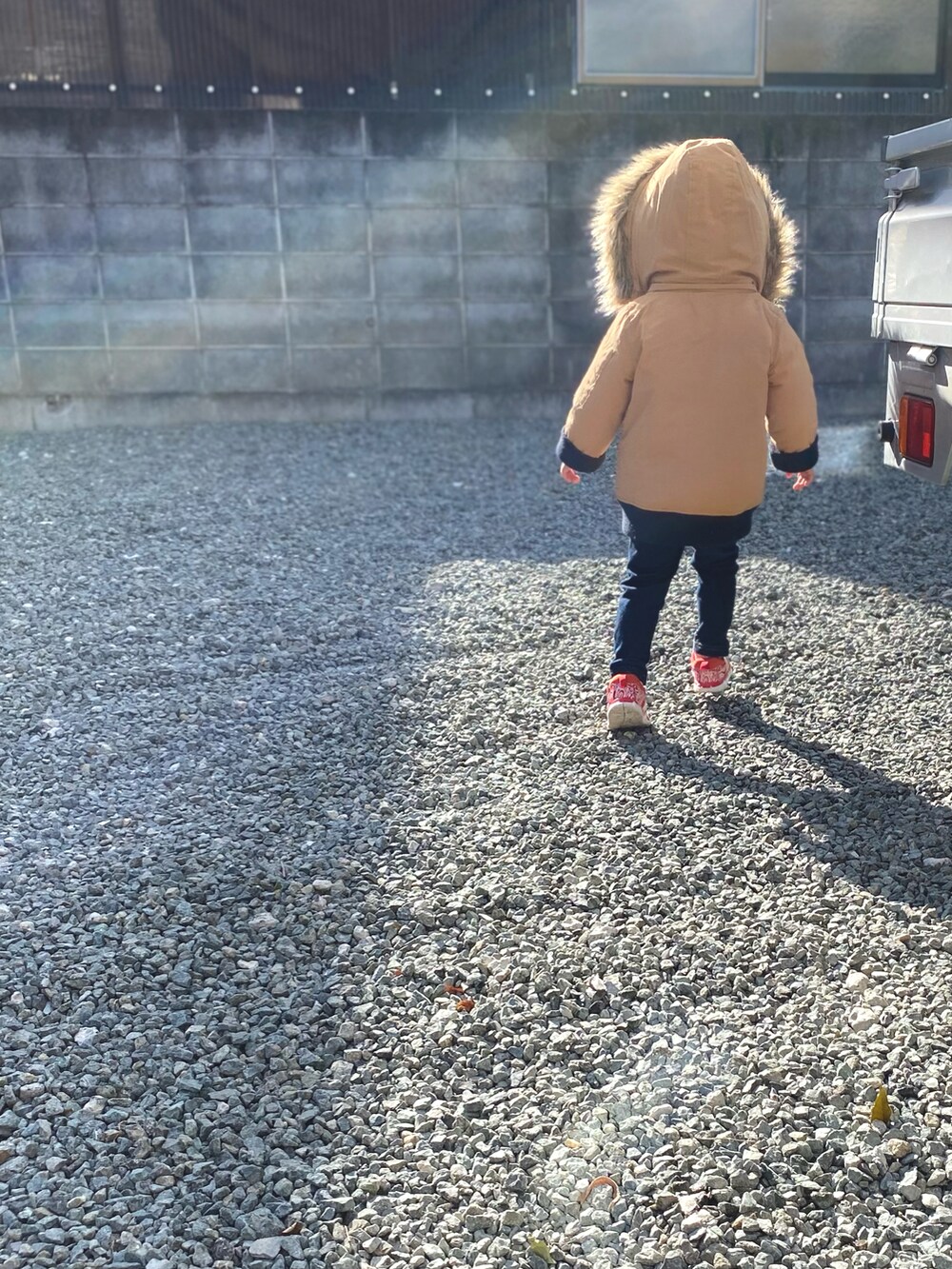 ベージュ系のその他アウター、レッド系のスニーカー、ブラック系のその他パンツを着用したキッズの冬コーディネートの2枚目の写真