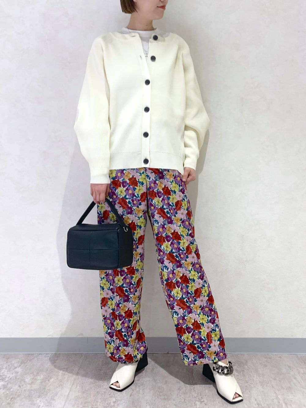 ホワイト系のその他パンツ、ホワイト系のパンプス、ブラック系のショルダーバッグを着用したレディースの冬コーディネートの2枚目の写真