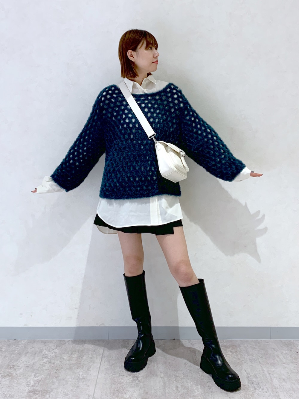 ブラック系のブーツ、ブラック系のパンツ、ホワイト系のシャツ/ブラウスを着用したレディースの秋コーディネートの2枚目の写真