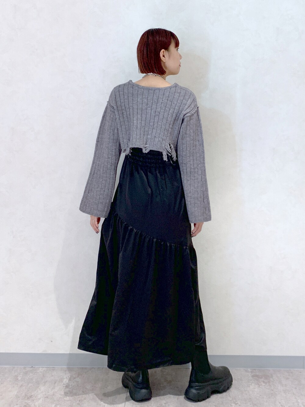 グレー系のワンピース、ブラック系のブーツを着用したレディースの秋コーディネートの4枚目の写真