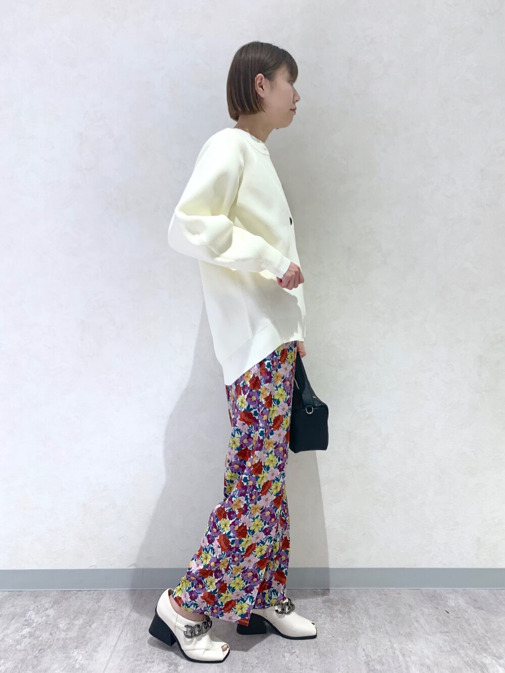 ホワイト系のその他パンツ、ホワイト系のパンプス、ブラック系のショルダーバッグを着用したレディースの冬コーディネートの3枚目の写真