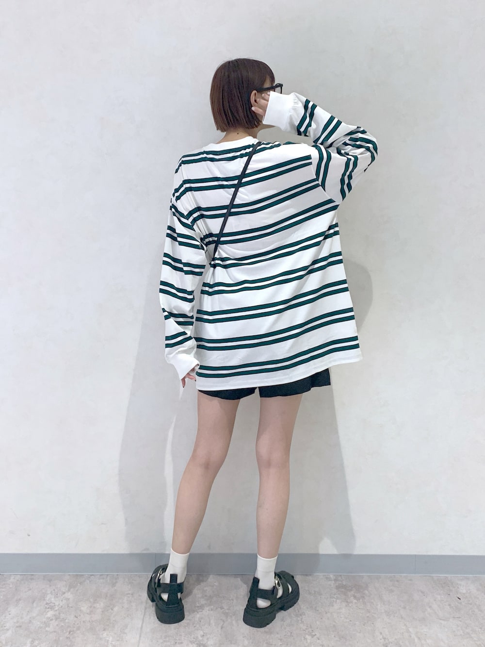 ブラック系のサンダル、ブラック系のショルダーバッグ、ホワイト系のTシャツ/カットソーを着用したレディースの夏コーディネートの4枚目の写真