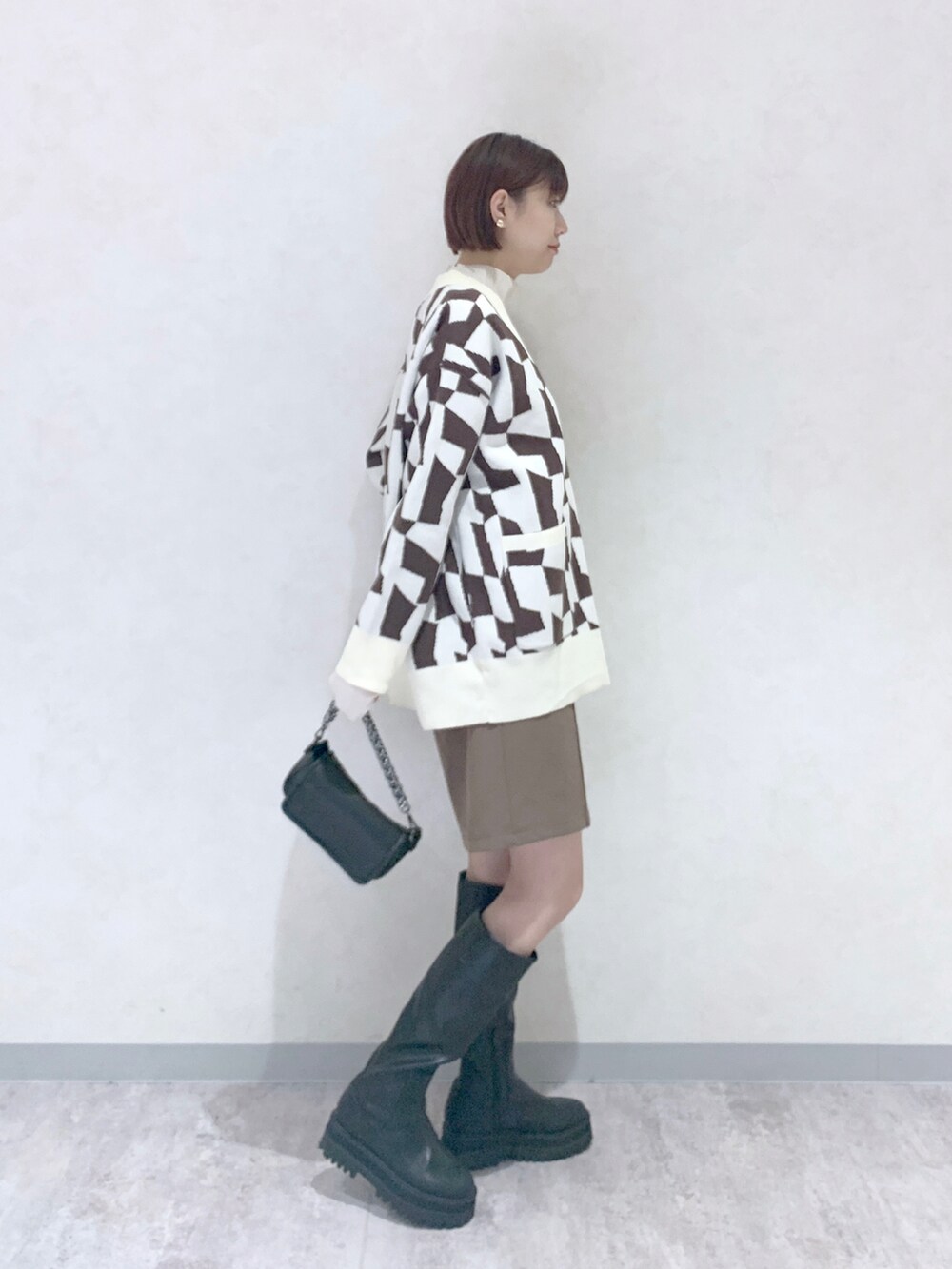 ブラック系のブーツ、ブラウン系のその他パンツ、ブラウン系のカーディガン/ボレロを着用したレディースの秋コーディネートの3枚目の写真