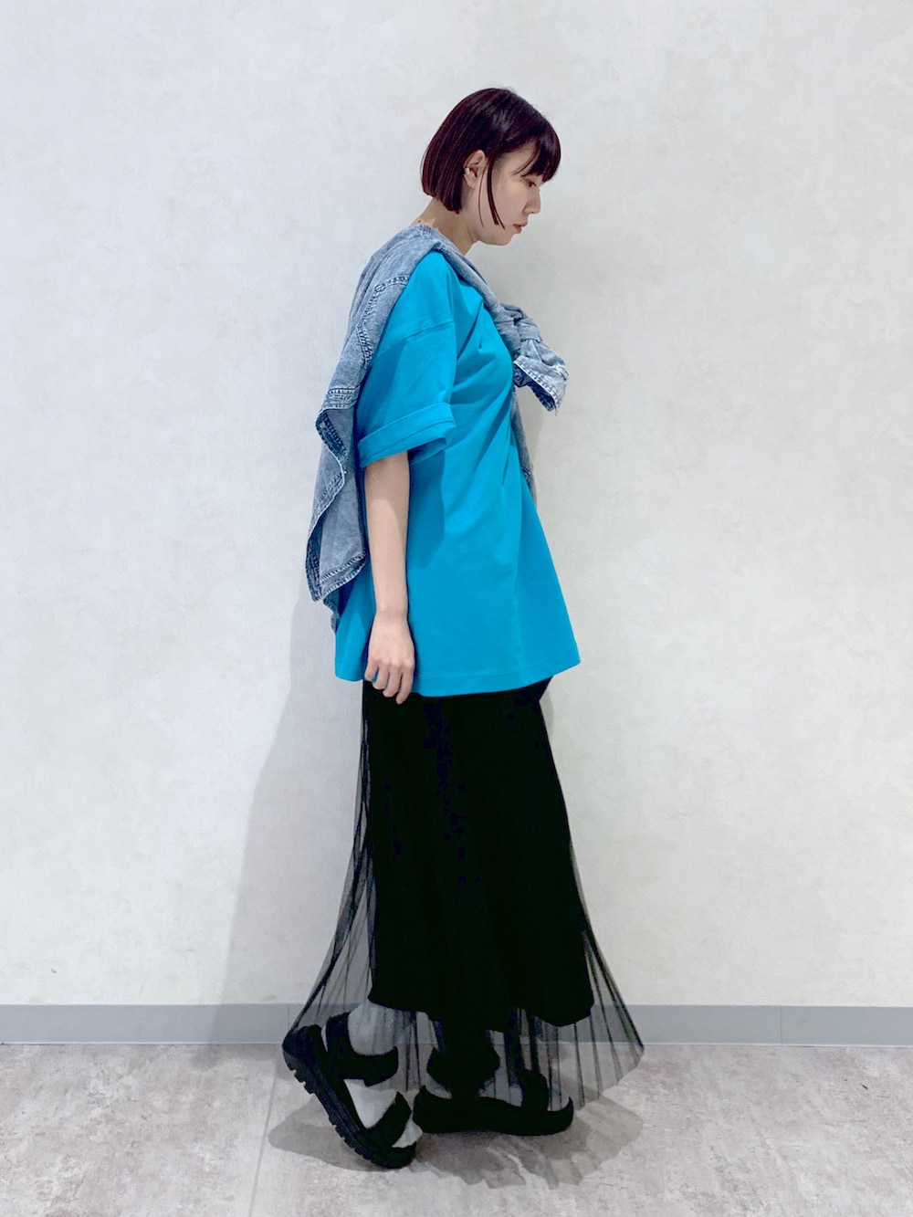 ブラック系のサンダル、ブラック系のスカート、ブルー系のシャツ/ブラウスを着用したレディースの春コーディネートの3枚目の写真