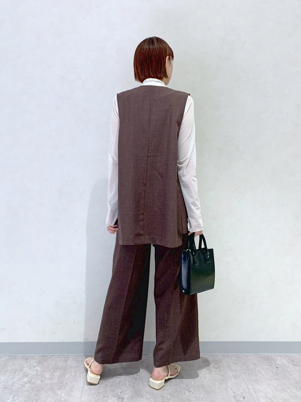 ホワイト系のサンダル、ブラック系のショルダーバッグ、ブラウン系のその他パンツを着用したレディースの春コーディネートの4枚目の写真