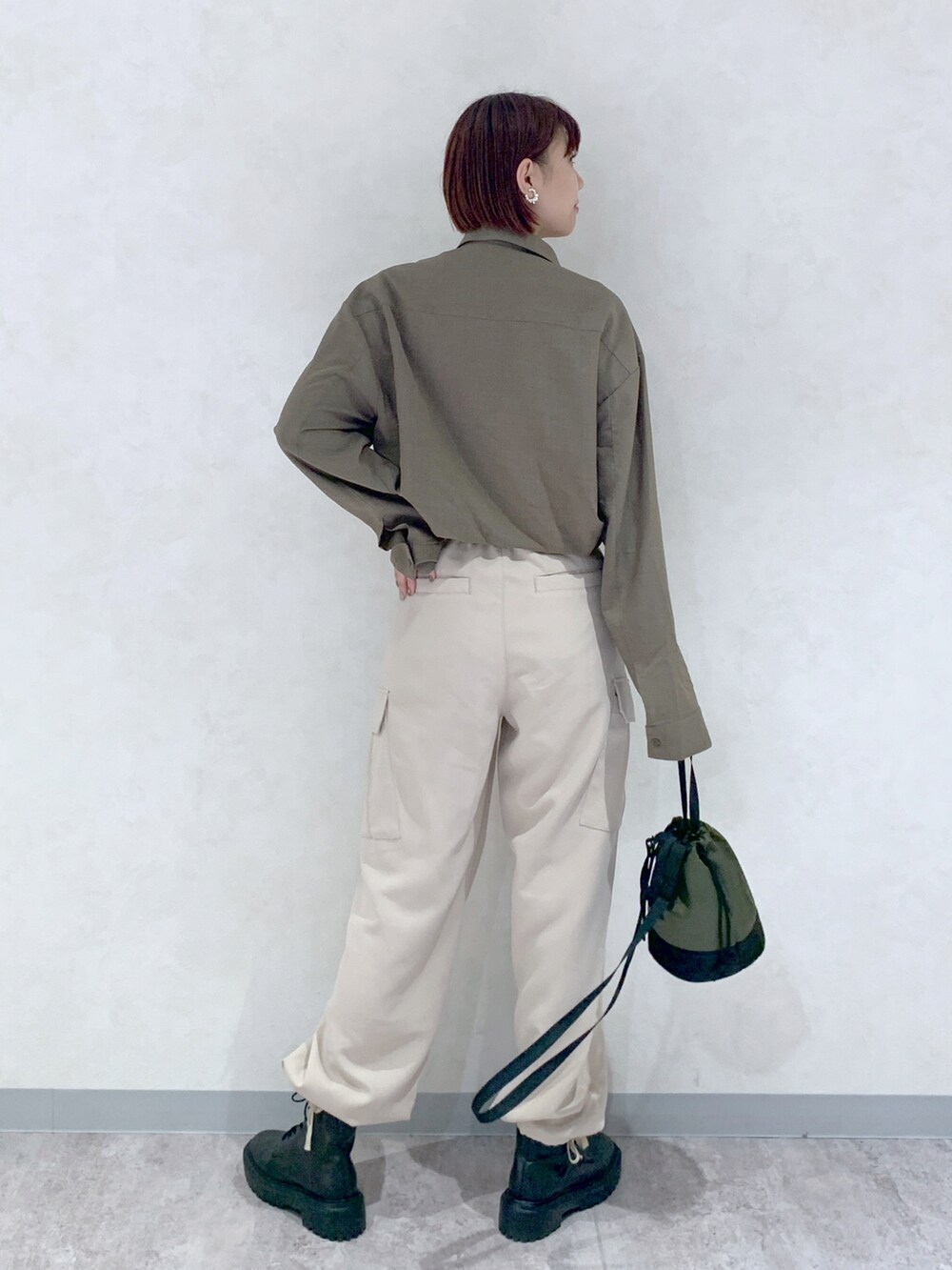 ブラウン系のシャツ/ブラウス、ベージュ系のパンツ、ブラック系のブーツを着用したレディースの秋コーディネートの4枚目の写真