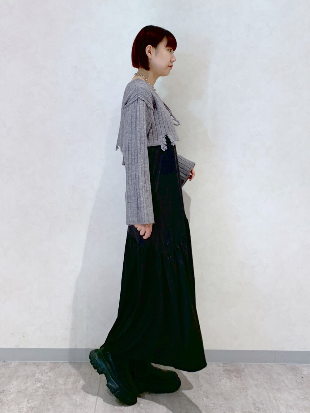 グレー系のワンピース、ブラック系のブーツを着用したレディースの秋コーディネートの3枚目の写真