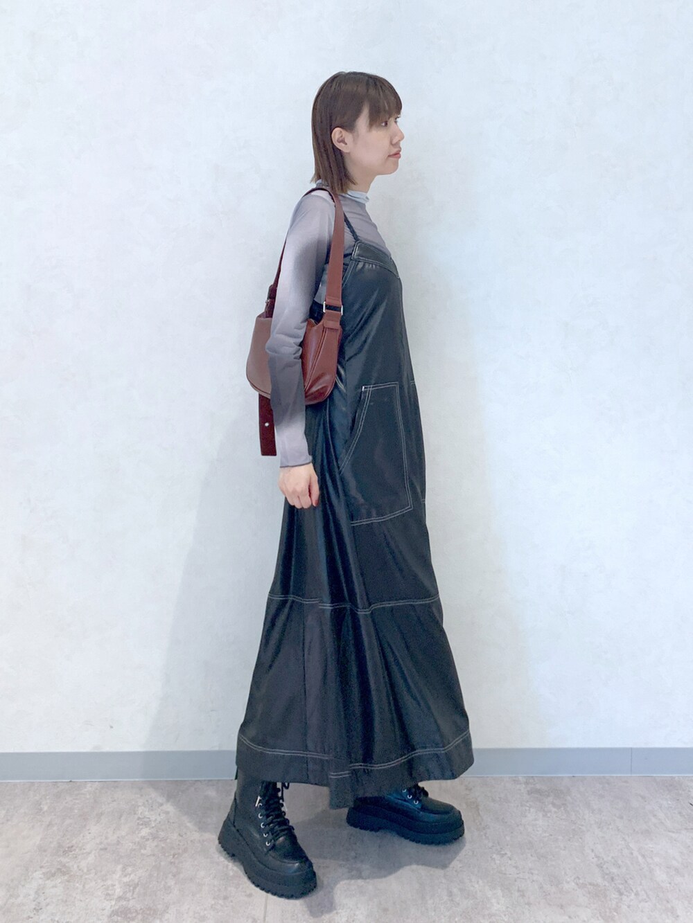 ブラック系のワンピース、ブラック系のブーツ、ブラウン系のショルダーバッグを着用したレディースの夏コーディネートの3枚目の写真