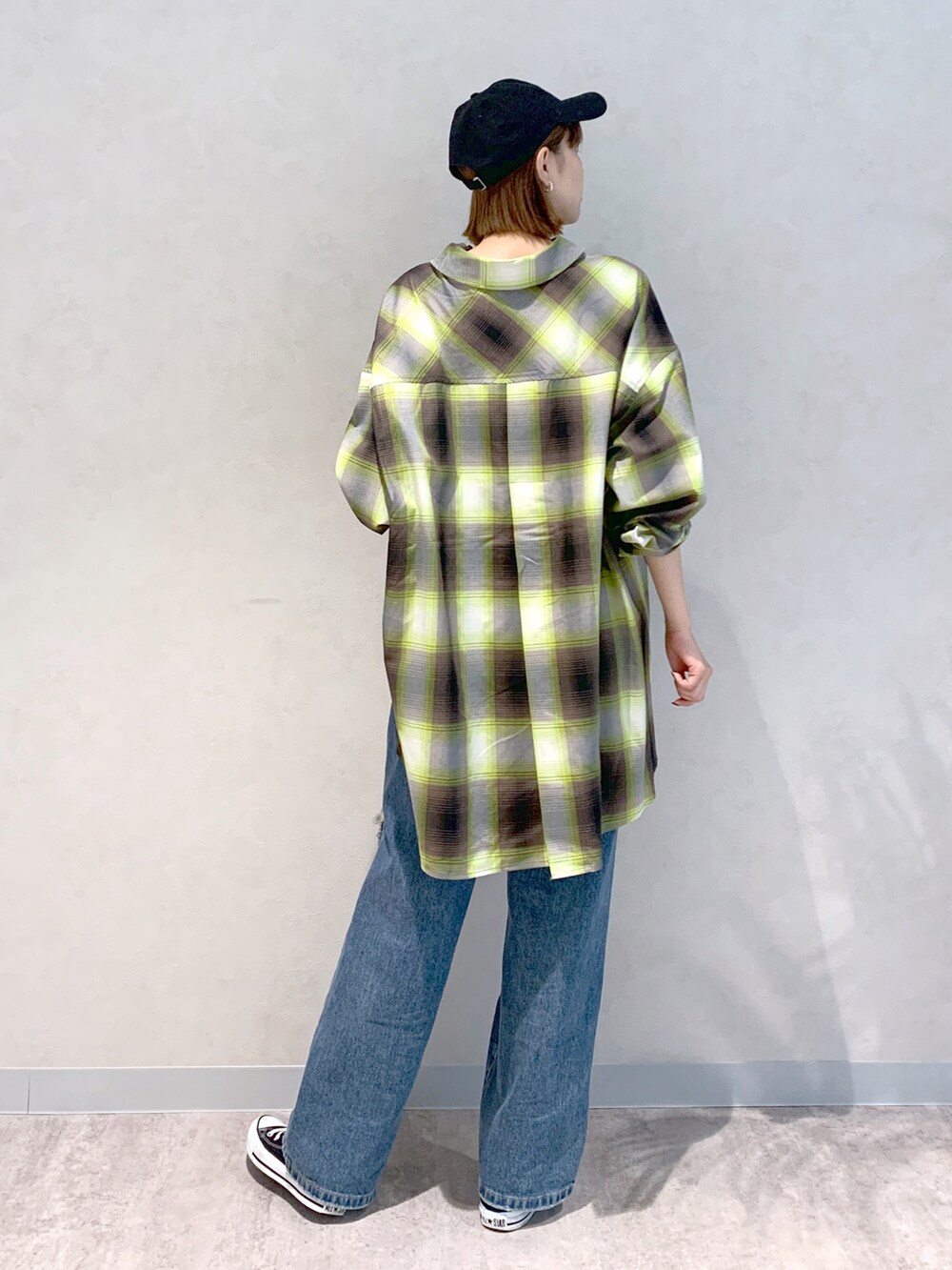 ブルー系のデニムパンツ、グリーン系のシャツ/ブラウス、ブラック系のキャップを着用したレディースの秋コーディネートの4枚目の写真