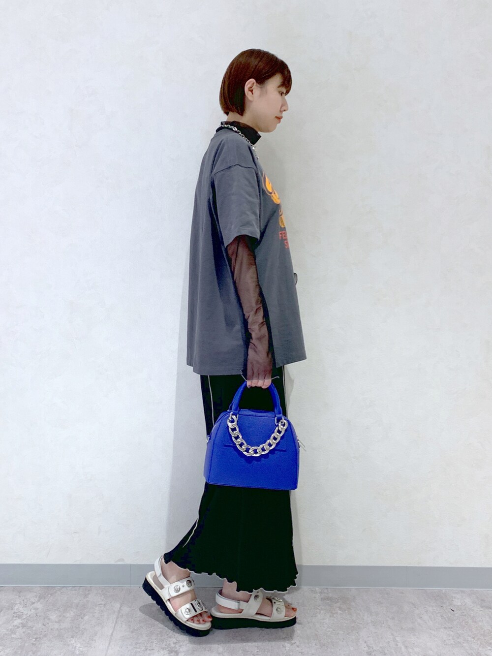 ブルー系のショルダーバッグ、ホワイト系のサンダル、ブラック系のスカートを着用したレディースの春コーディネートの2枚目の写真