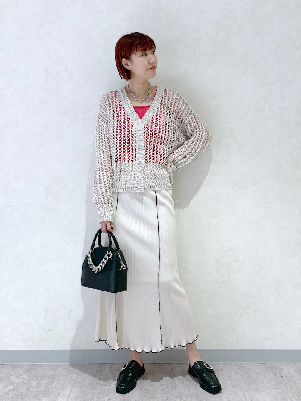 ブラック系のショルダーバッグ、ブラック系のローファー、ホワイト系のカーディガン/ボレロを着用したレディースの春コーディネートの2枚目の写真