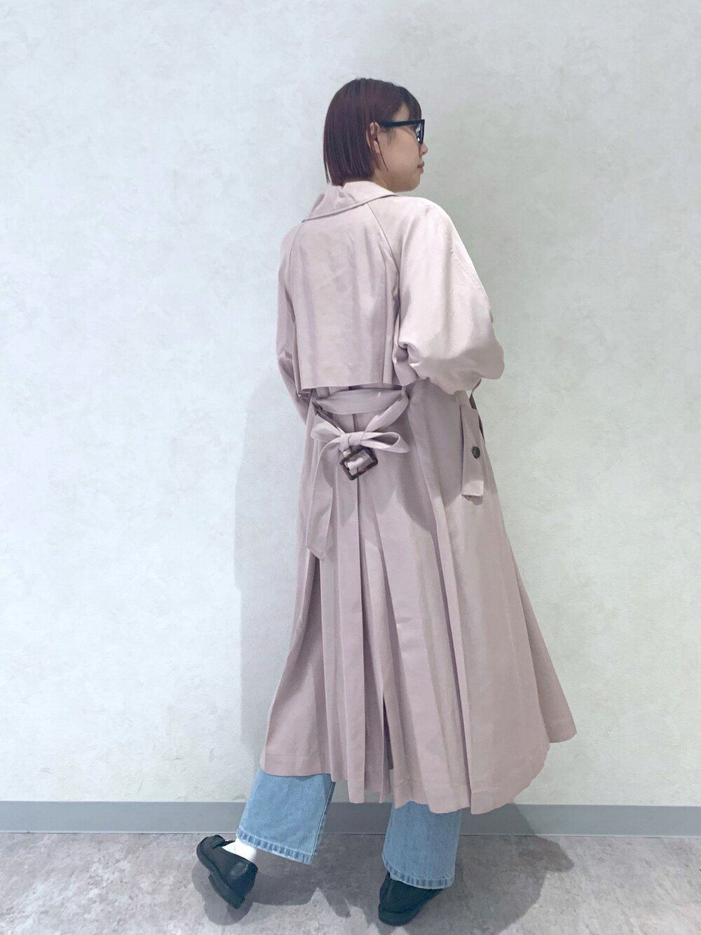 ブルー系のデニムパンツ、ベージュ系のトレンチコート、ブラック系のローファーを着用したレディースの春コーディネートの4枚目の写真